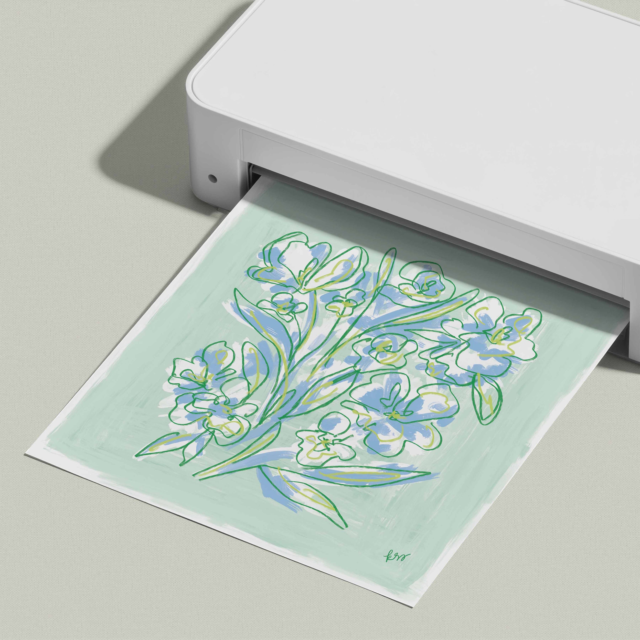 A white printer is printing a paper with a colorful floral design on it.