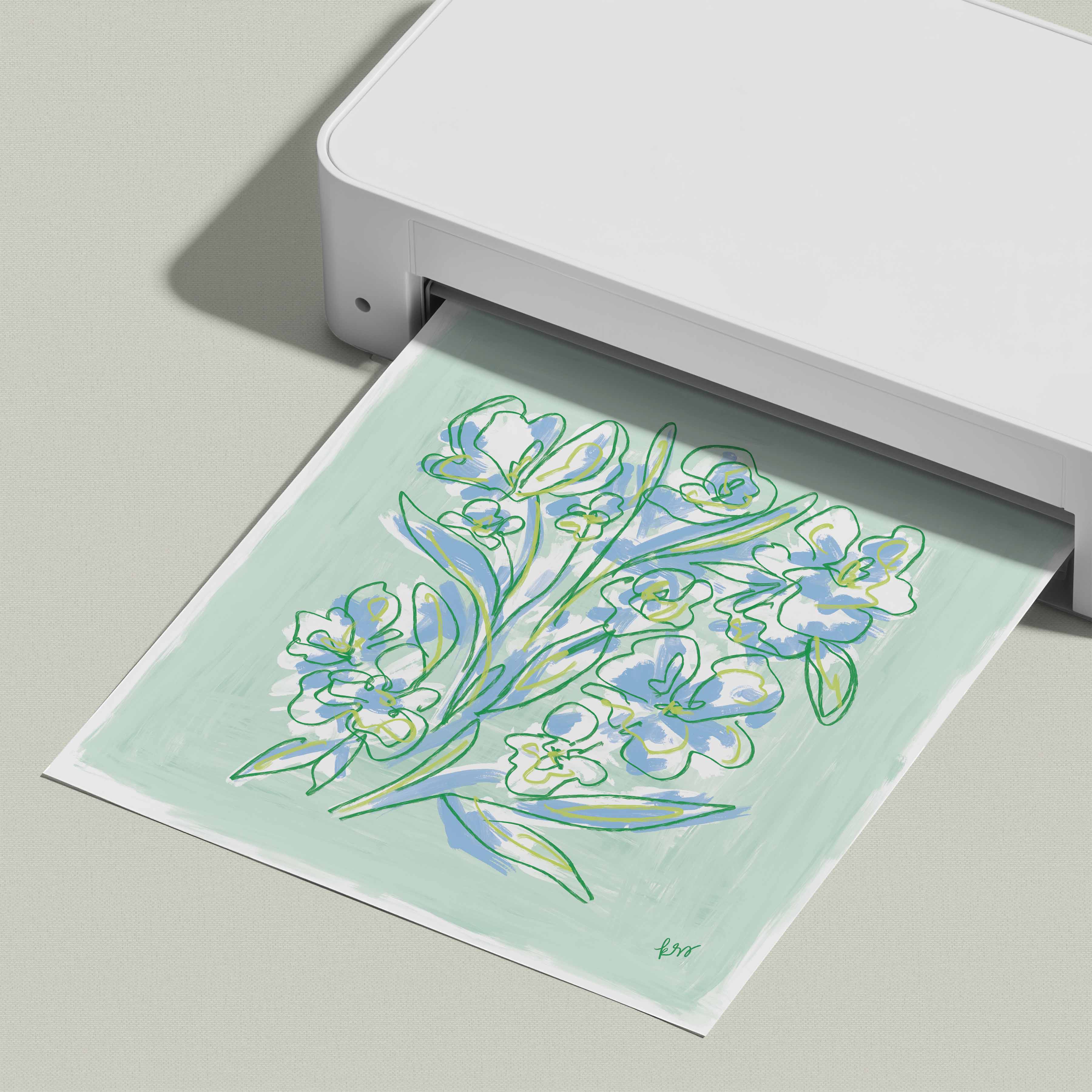 A white printer is printing a paper with a colorful floral design on it.