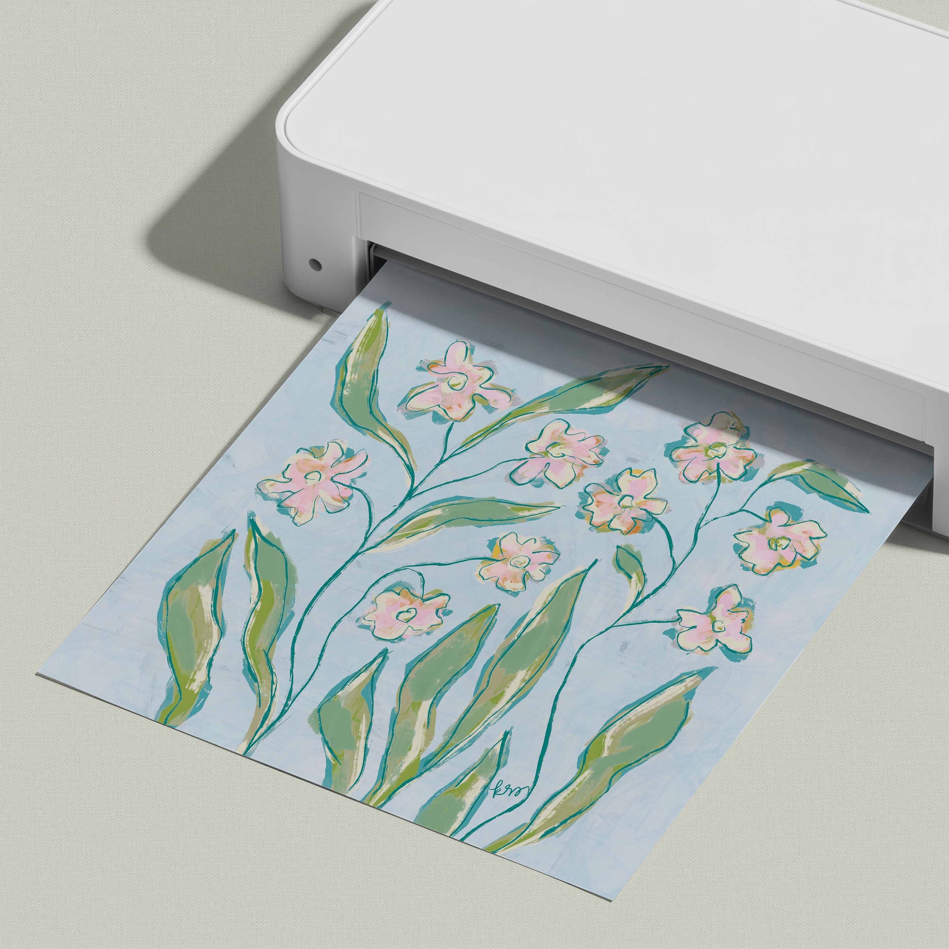 A white printer is shown in the image, with a printed paper featuring a floral design of pink flowers and green leaves.