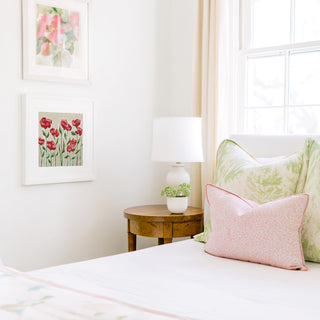 a cozy bedroom corner with a bed, a nightstand, and a framed artwork on the wall.