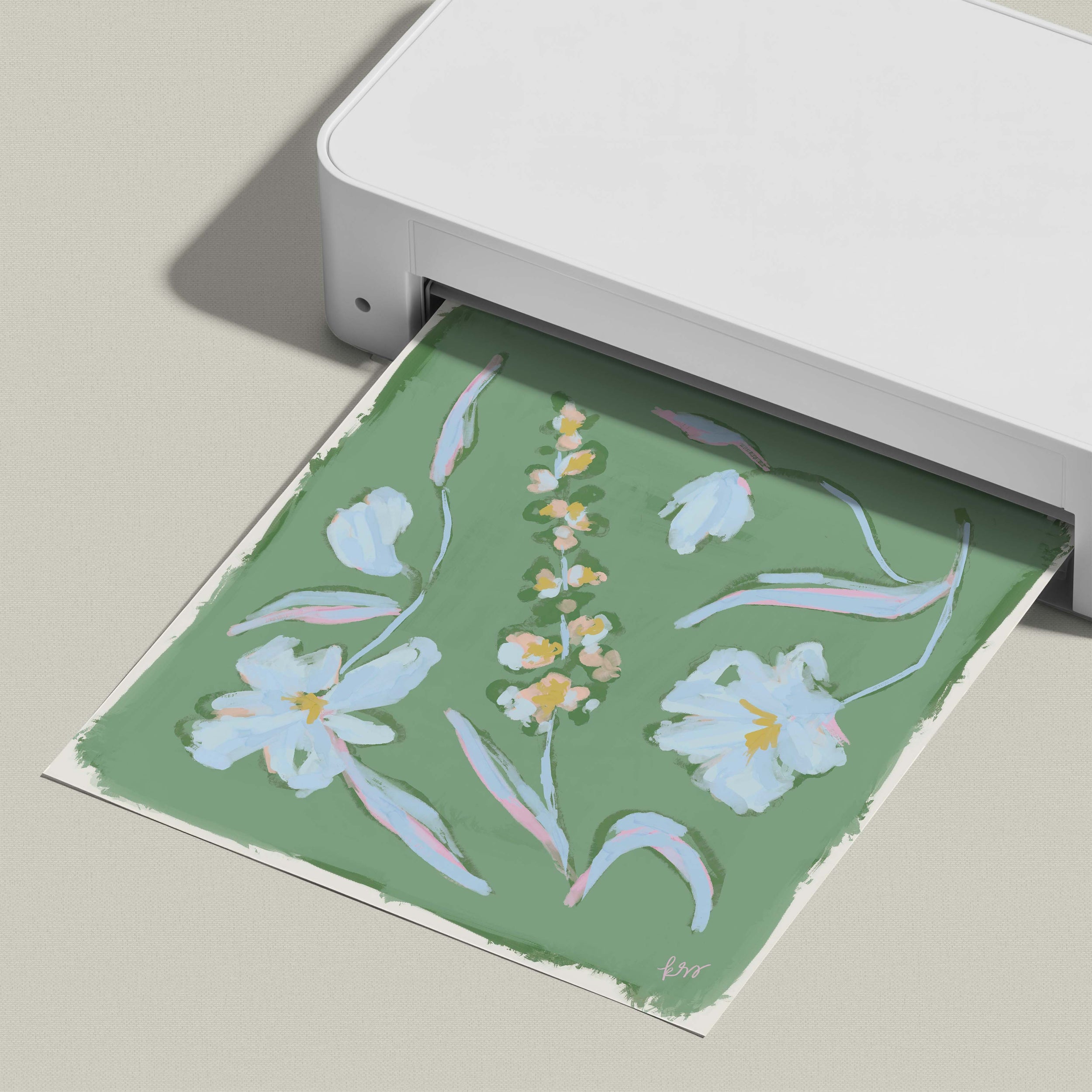 A white printer is printing a green and white floral design on a piece of paper.