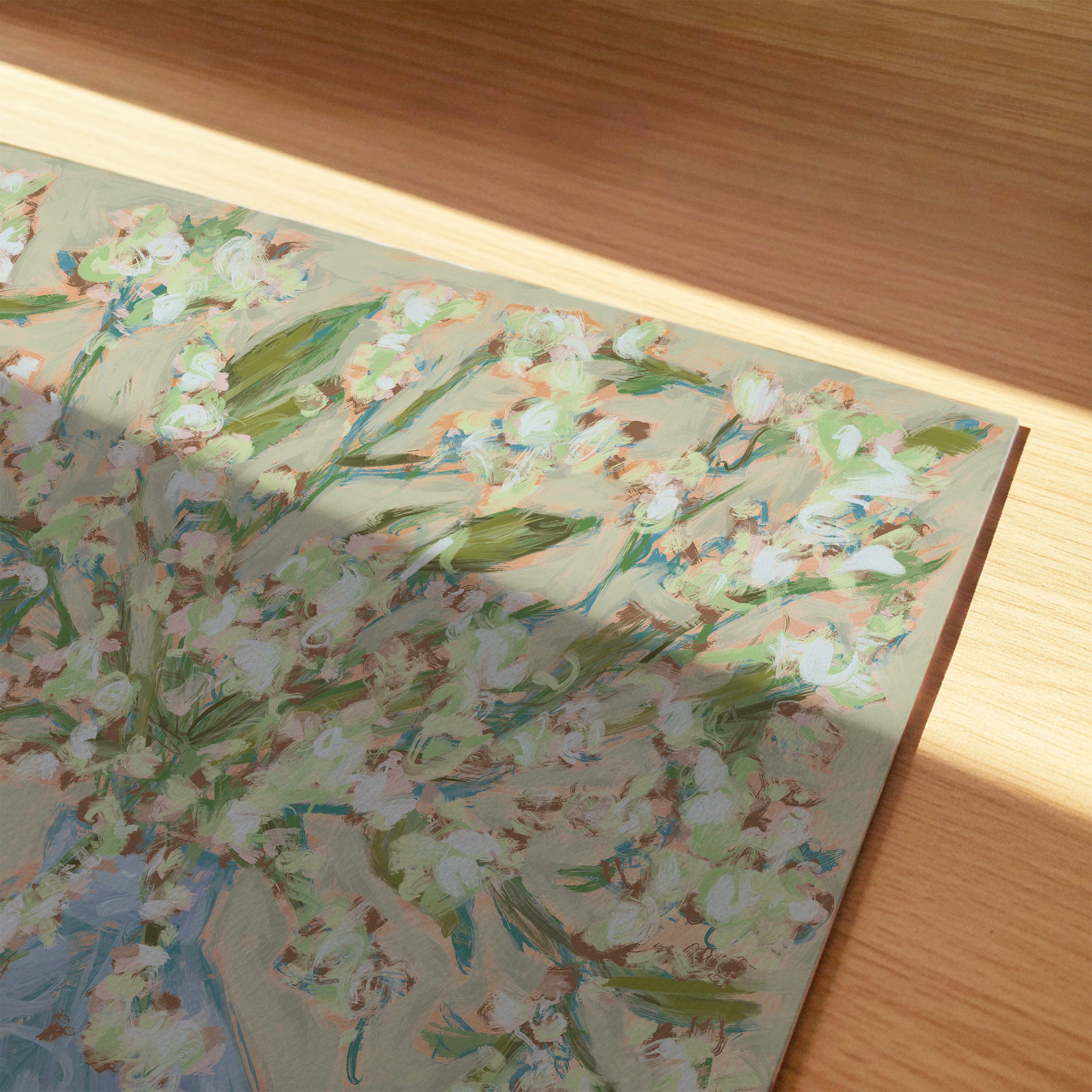 The image is a close-up of a painting with a floral pattern, featuring a variety of green and white flowers and leaves. The painting is placed on a wooden surface, and the lighting casts shadows on the painting, creating a sense of depth and texture.