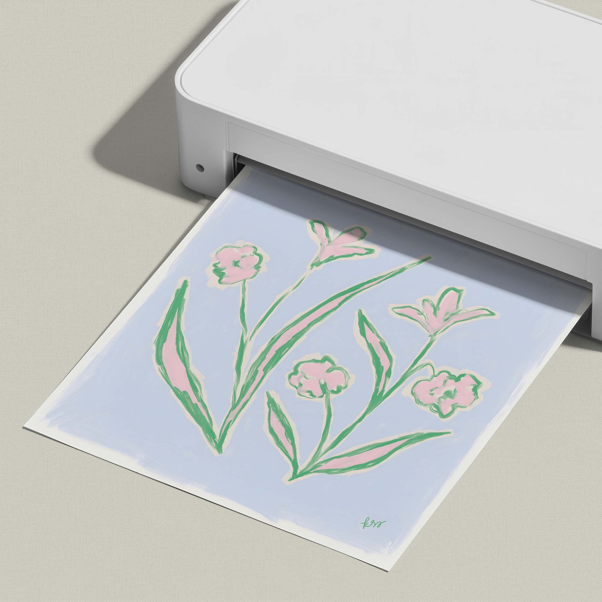 A white printer is printing a paper with a colorful floral design on it.
