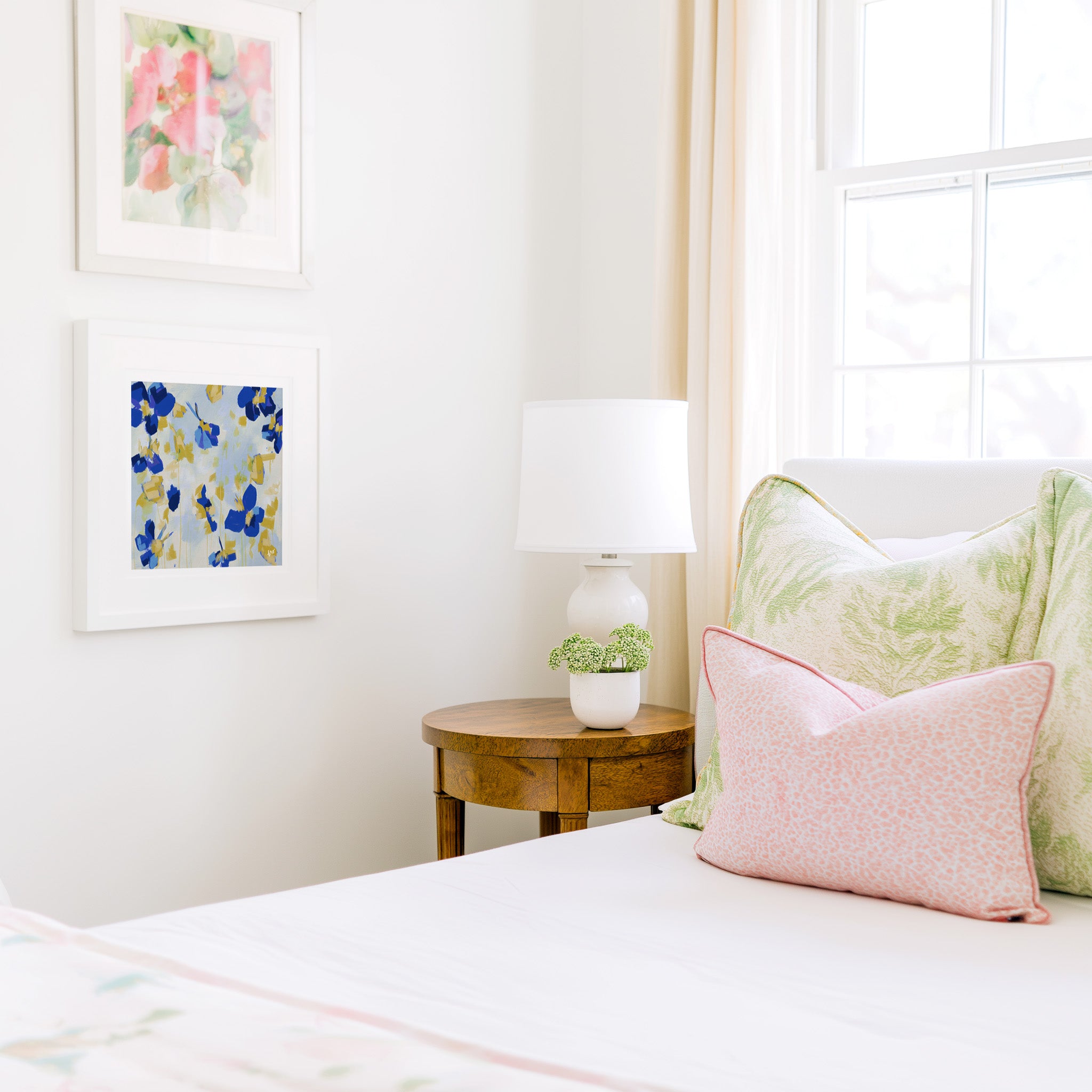 a cozy bedroom corner with a bed, a wooden nightstand, and a framed artwork on the wall.