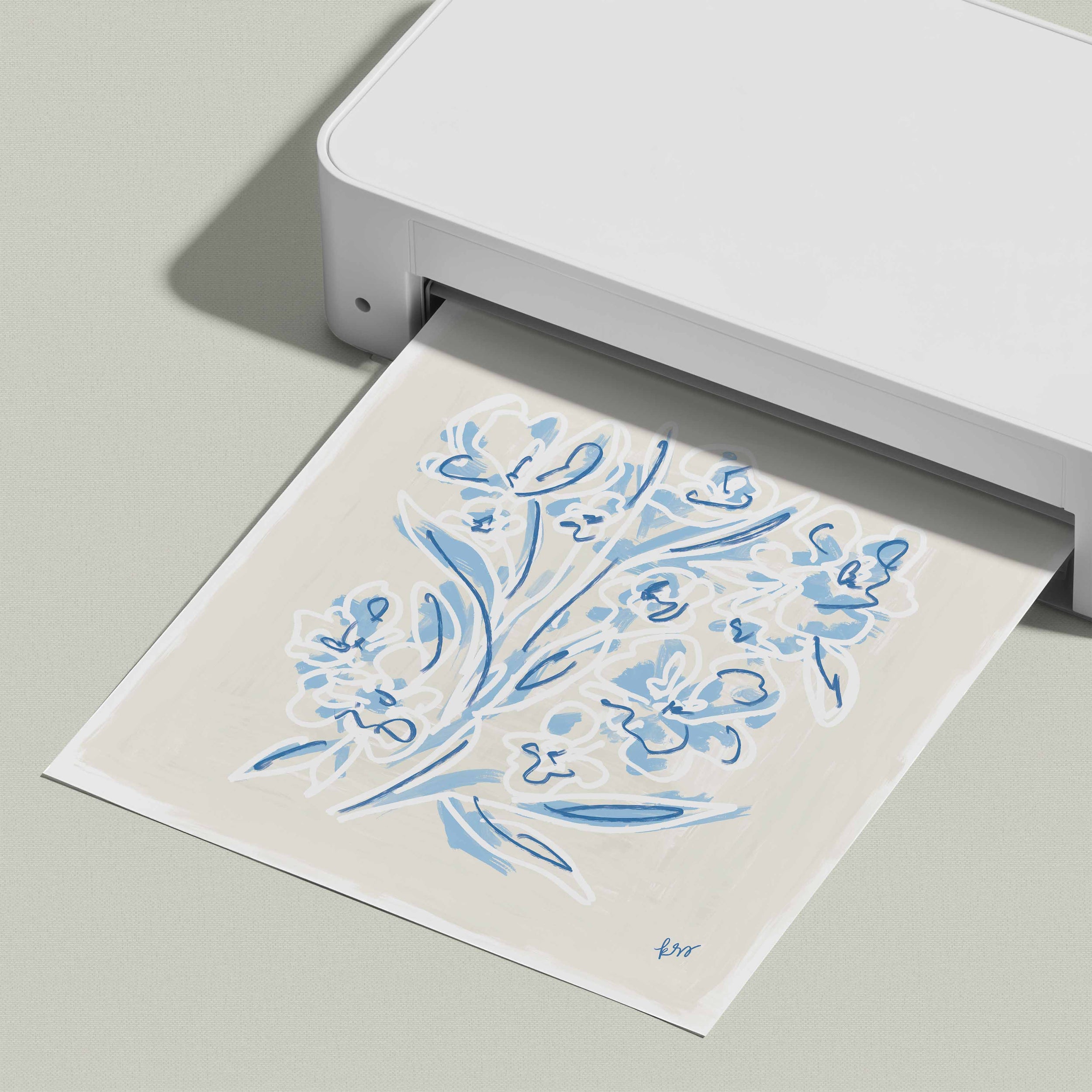 A white printer is shown in the image, with a printed paper displaying a blue floral design.