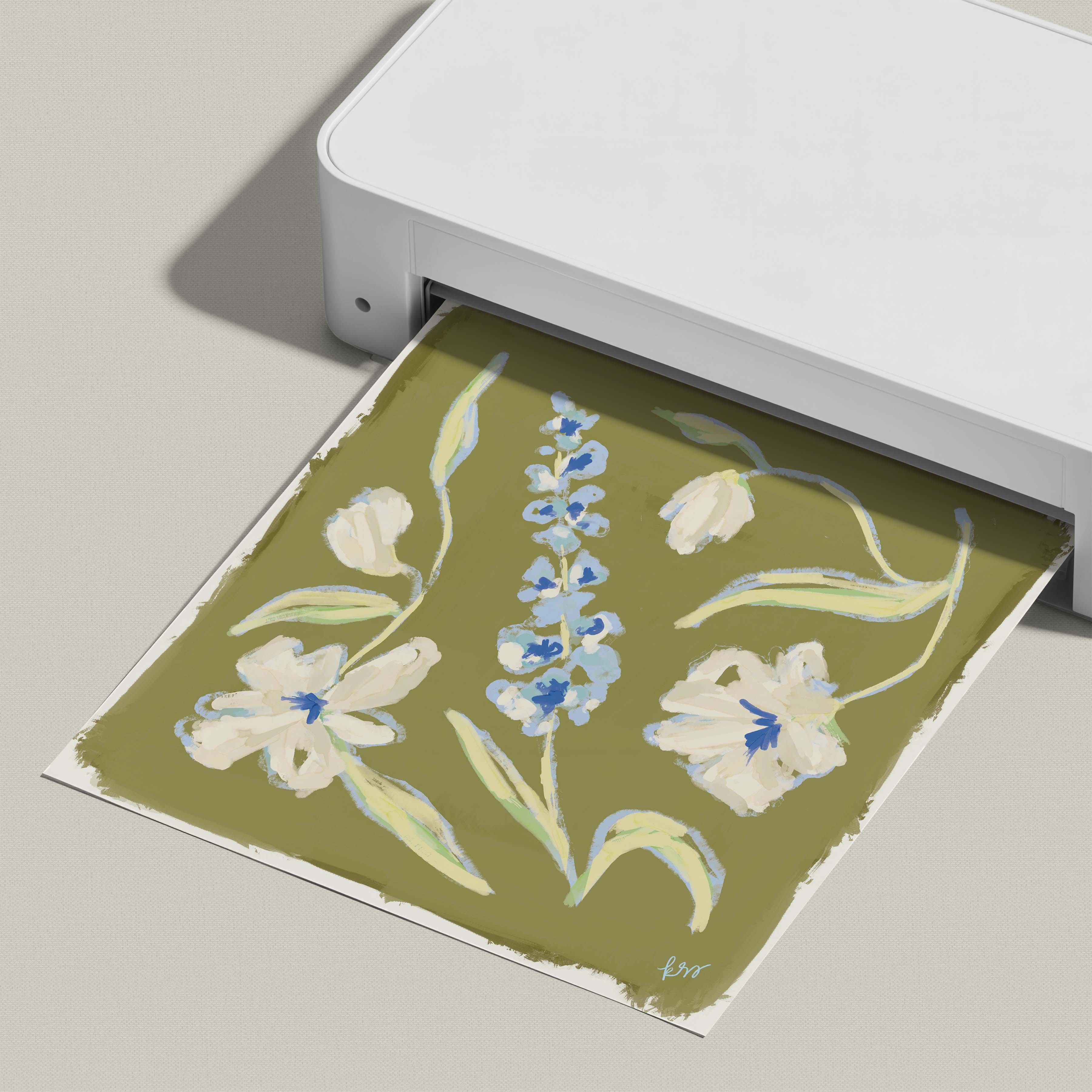 A printer is printing a floral design on a piece of paper, which features a variety of flowers and leaves in shades of green and white.