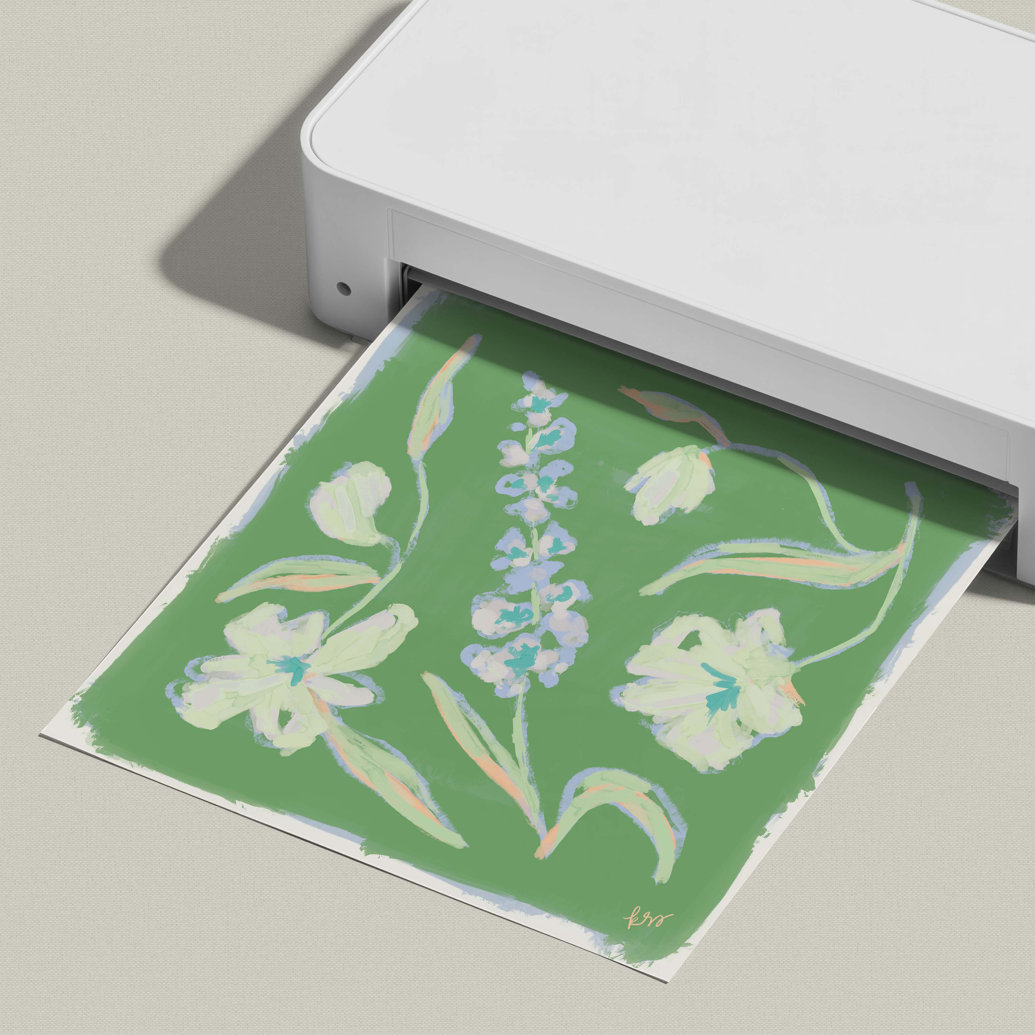 A white printer is printing a green and white floral design on a piece of paper.