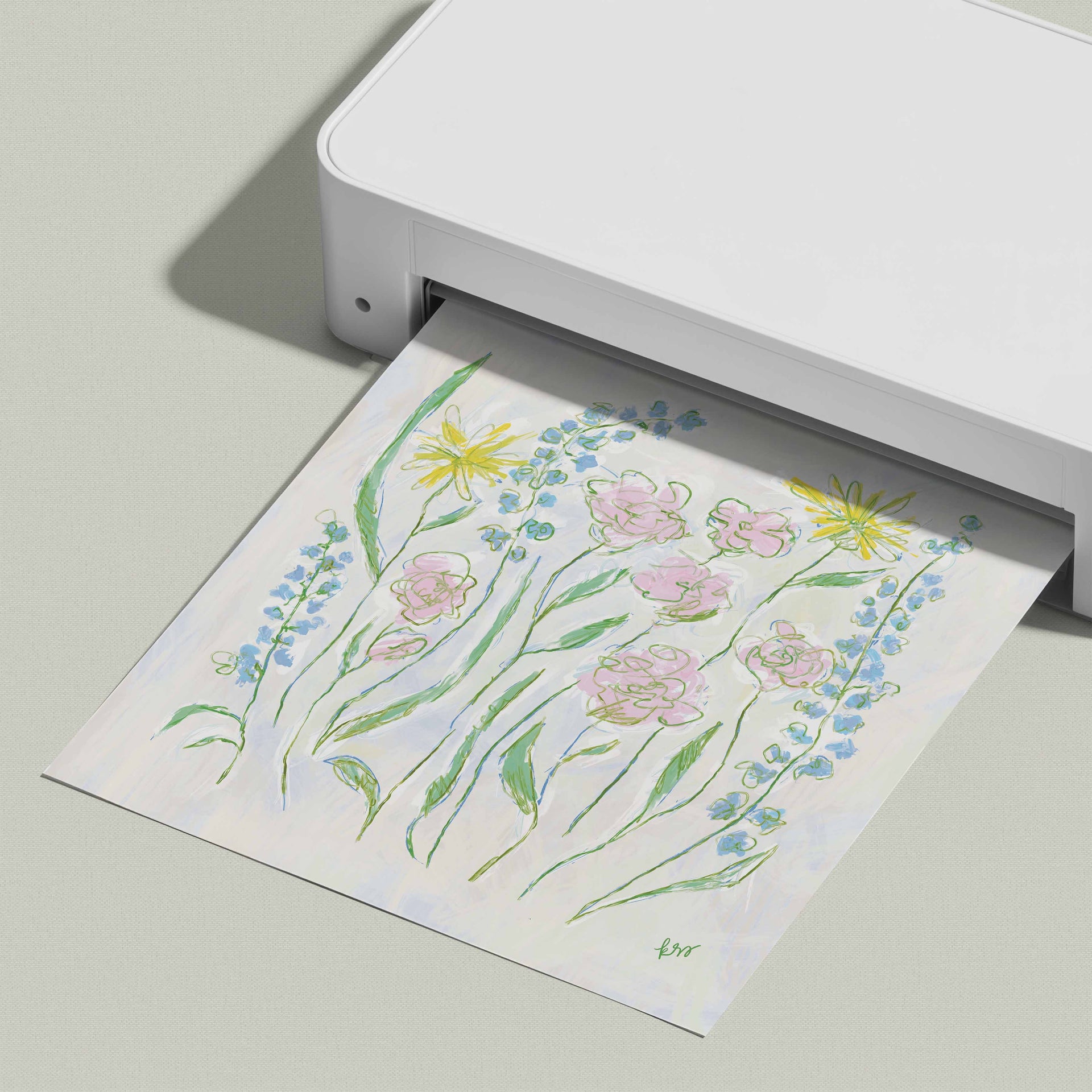 A white printer is displaying a colorful printed paper with a floral design.