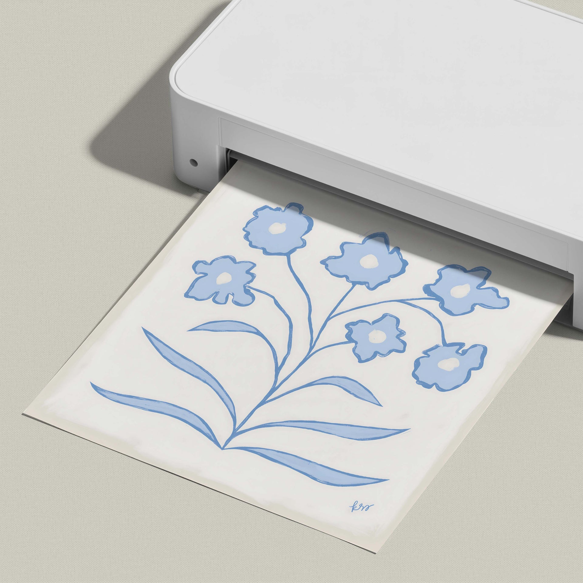 A white printer is shown in the image, with a printed paper displaying a blue floral design.