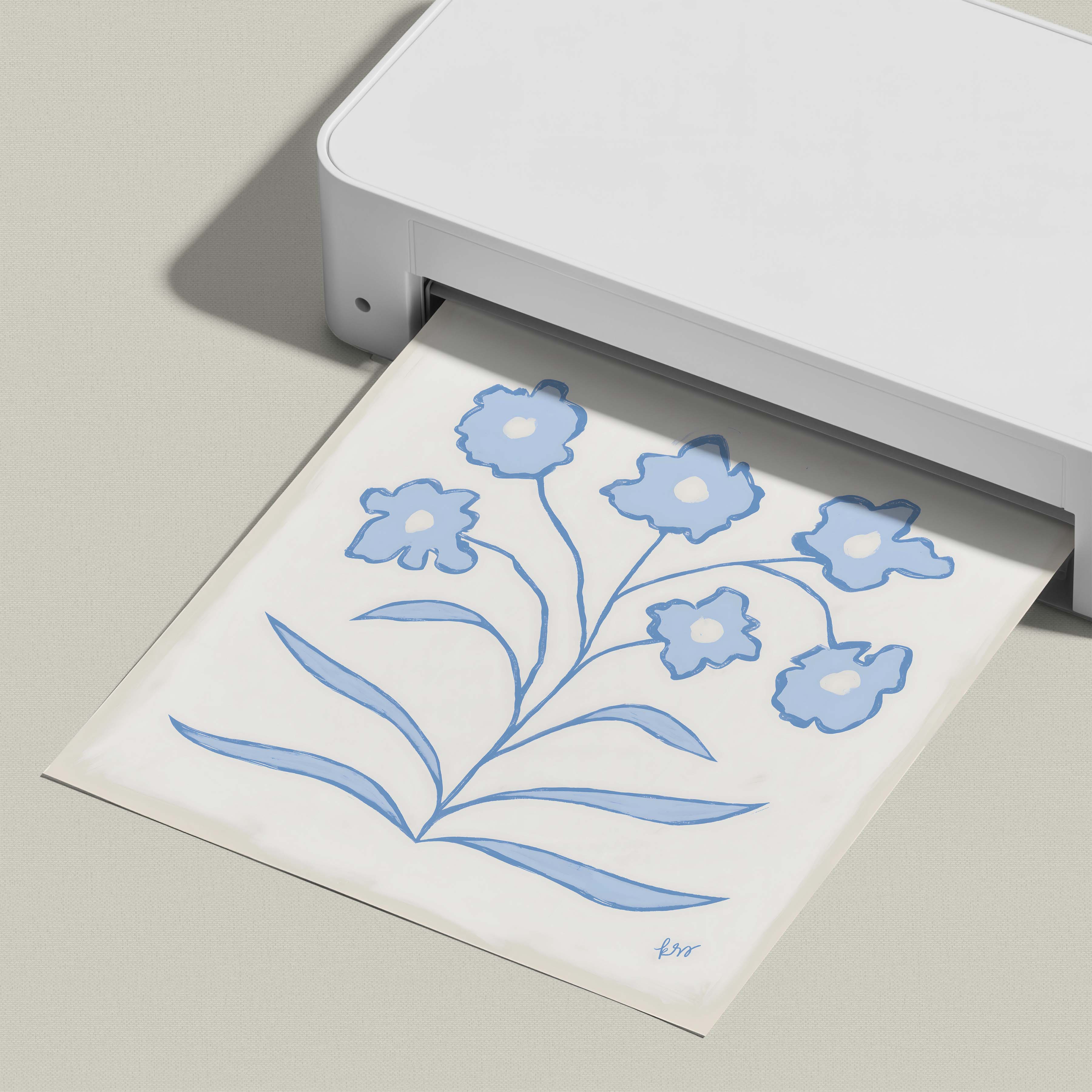 A white printer is shown in the image, with a printed paper displaying a blue floral design.
