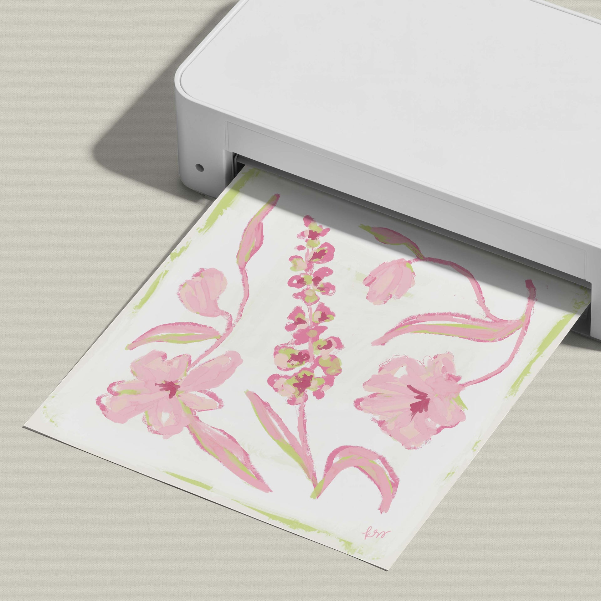 A white printer is displaying a printed paper with a floral design featuring pink flowers and green leaves.