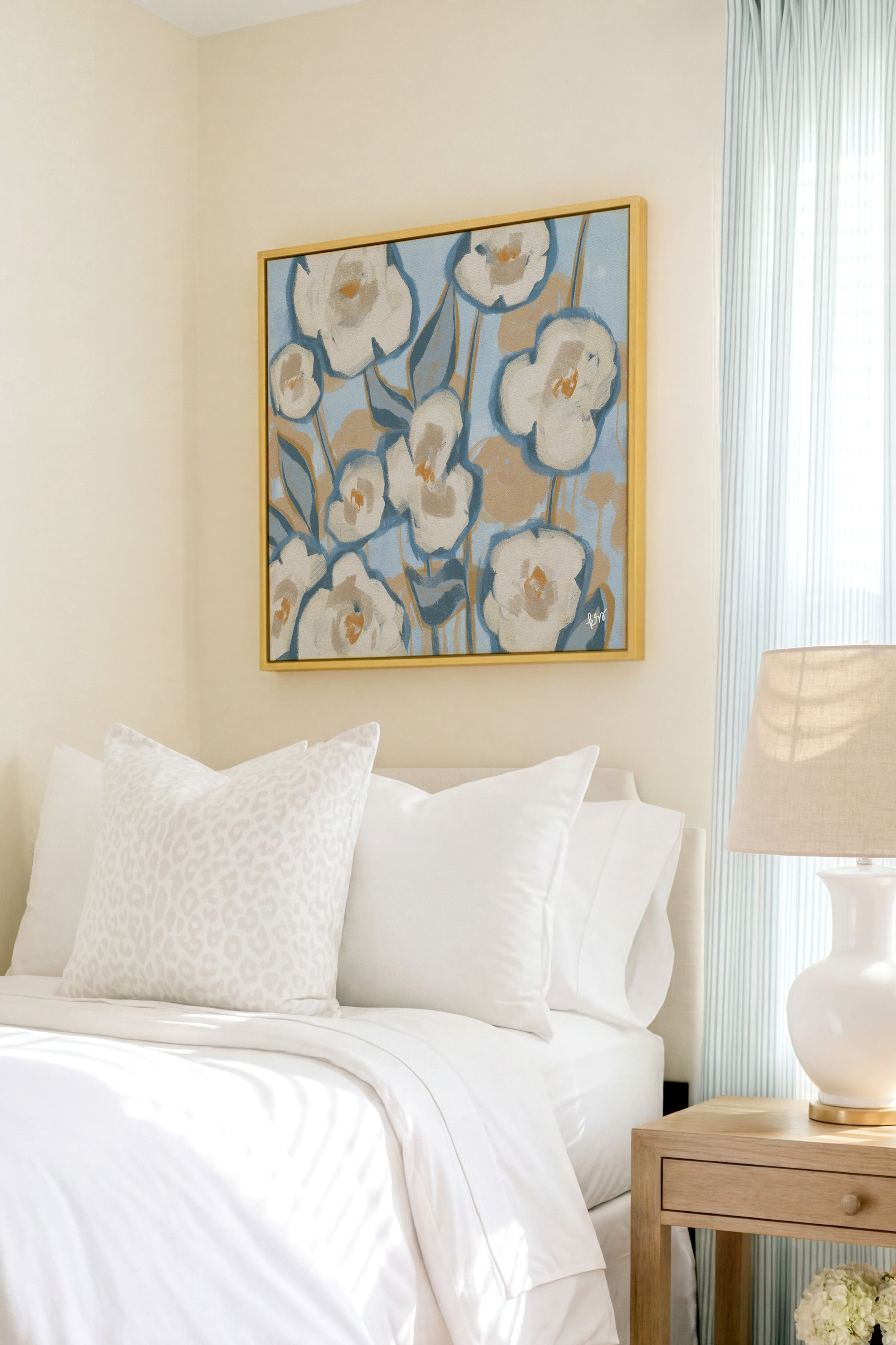a serene and well-decorated bedroom with a large floral painting hanging on the wall above a bed with white bedding and pillows.