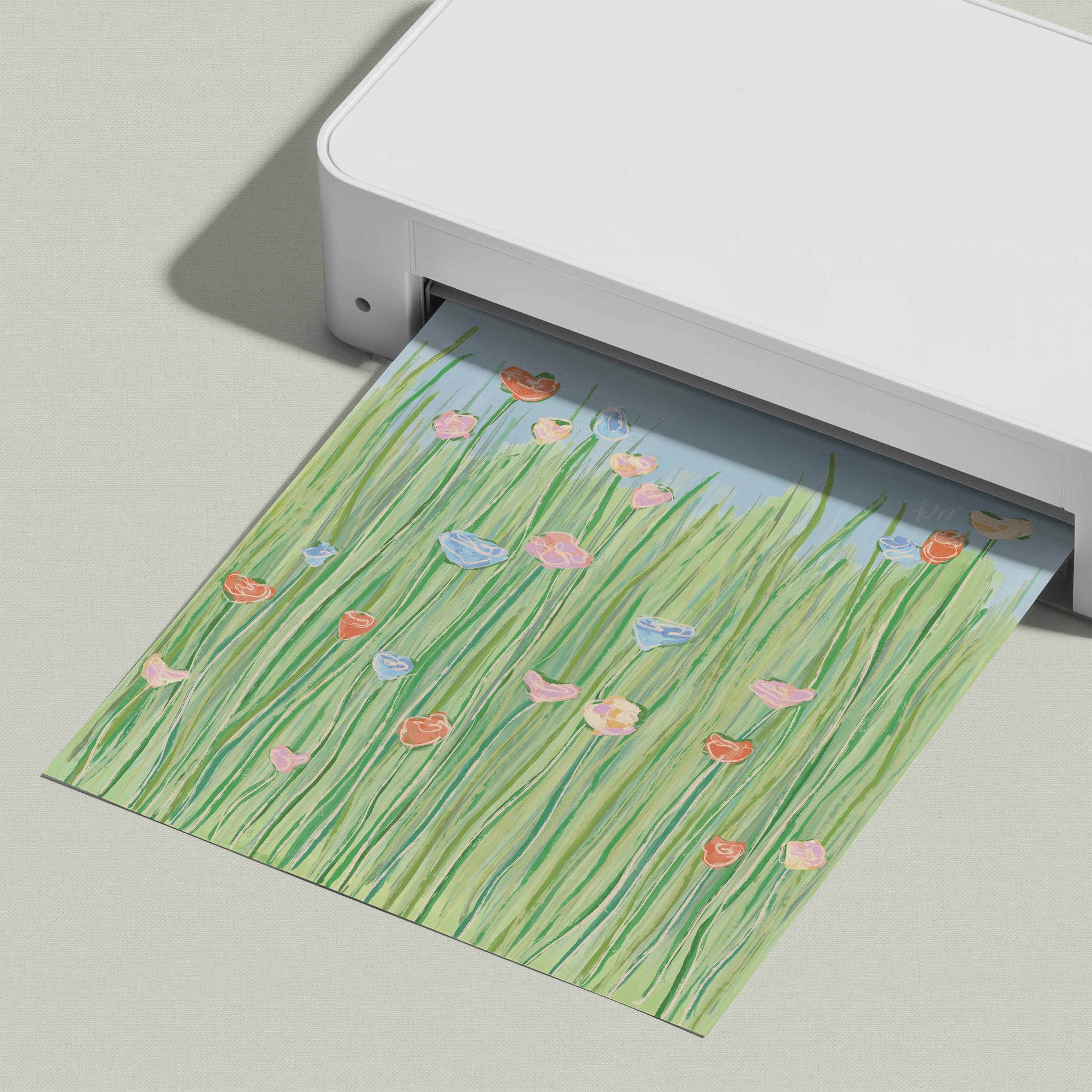 A white printer is shown with a printed paper featuring a colorful illustration of flowers and grass.