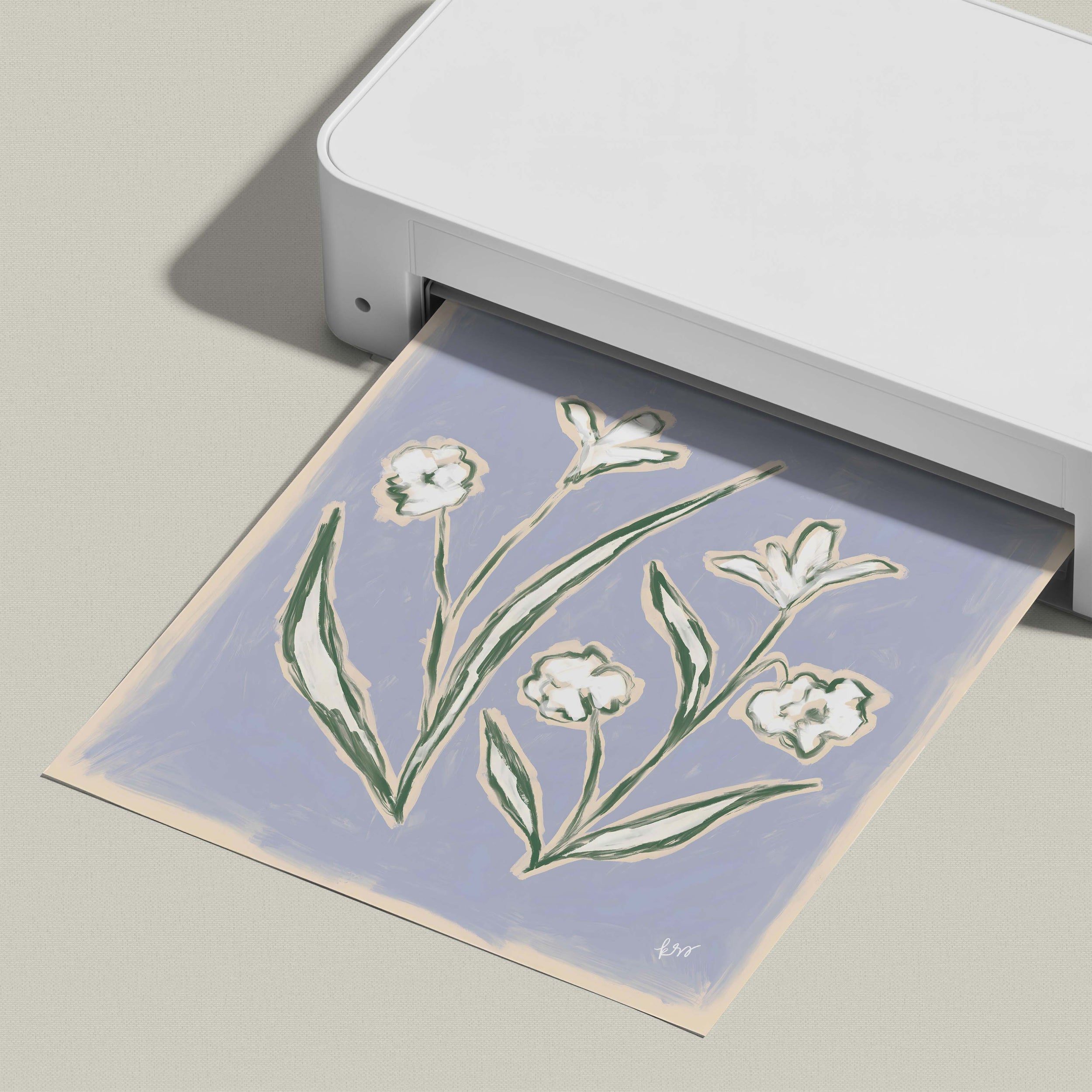 A white printer is printing a paper with a floral design on it.