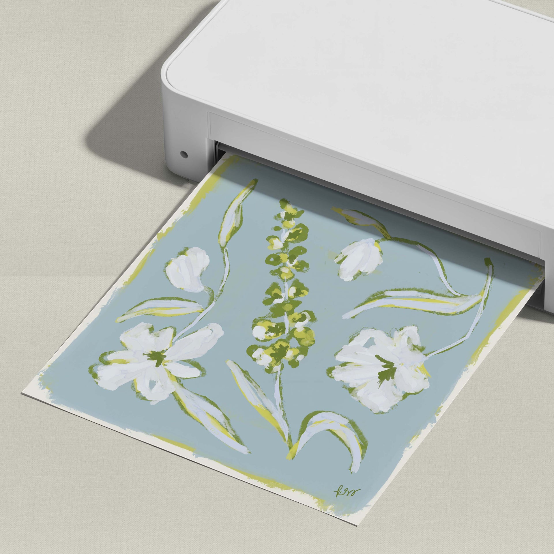 A white printer is shown in the image, with a printed paper featuring a floral design on it.