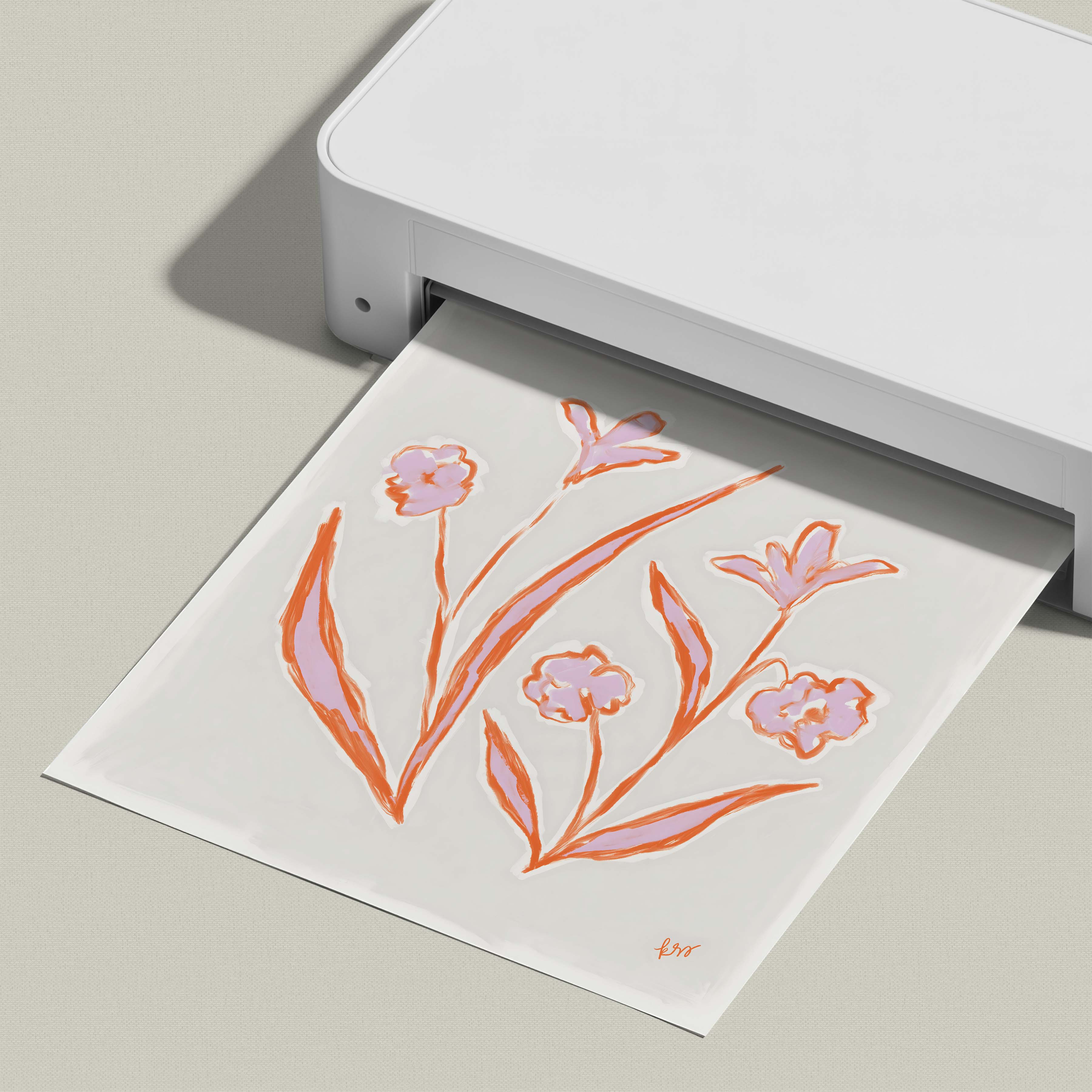 A white printer is printing a paper with an illustration of flowers in orange and pink colors.