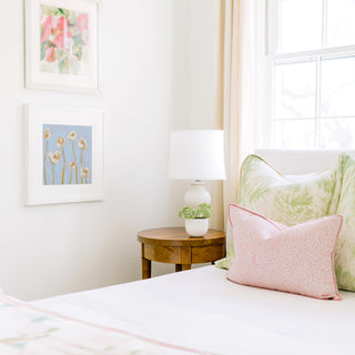 a cozy bedroom corner with a bed, a nightstand, and a framed artwork on the wall.