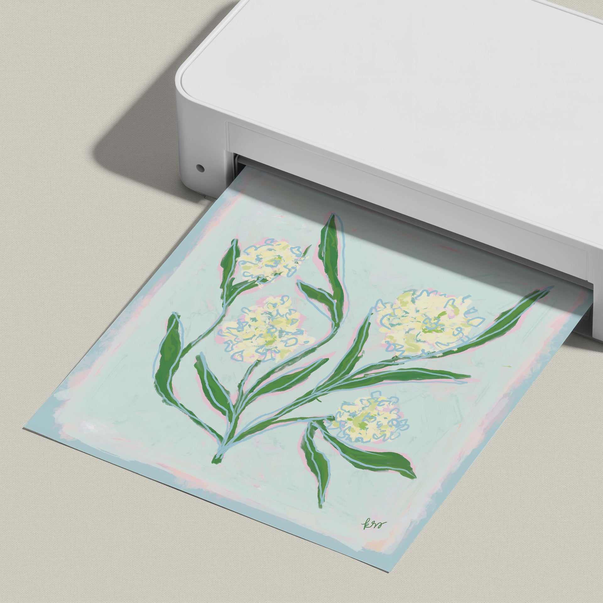 A white printer is displaying a colorful digital printout of a floral design on a light blue background.