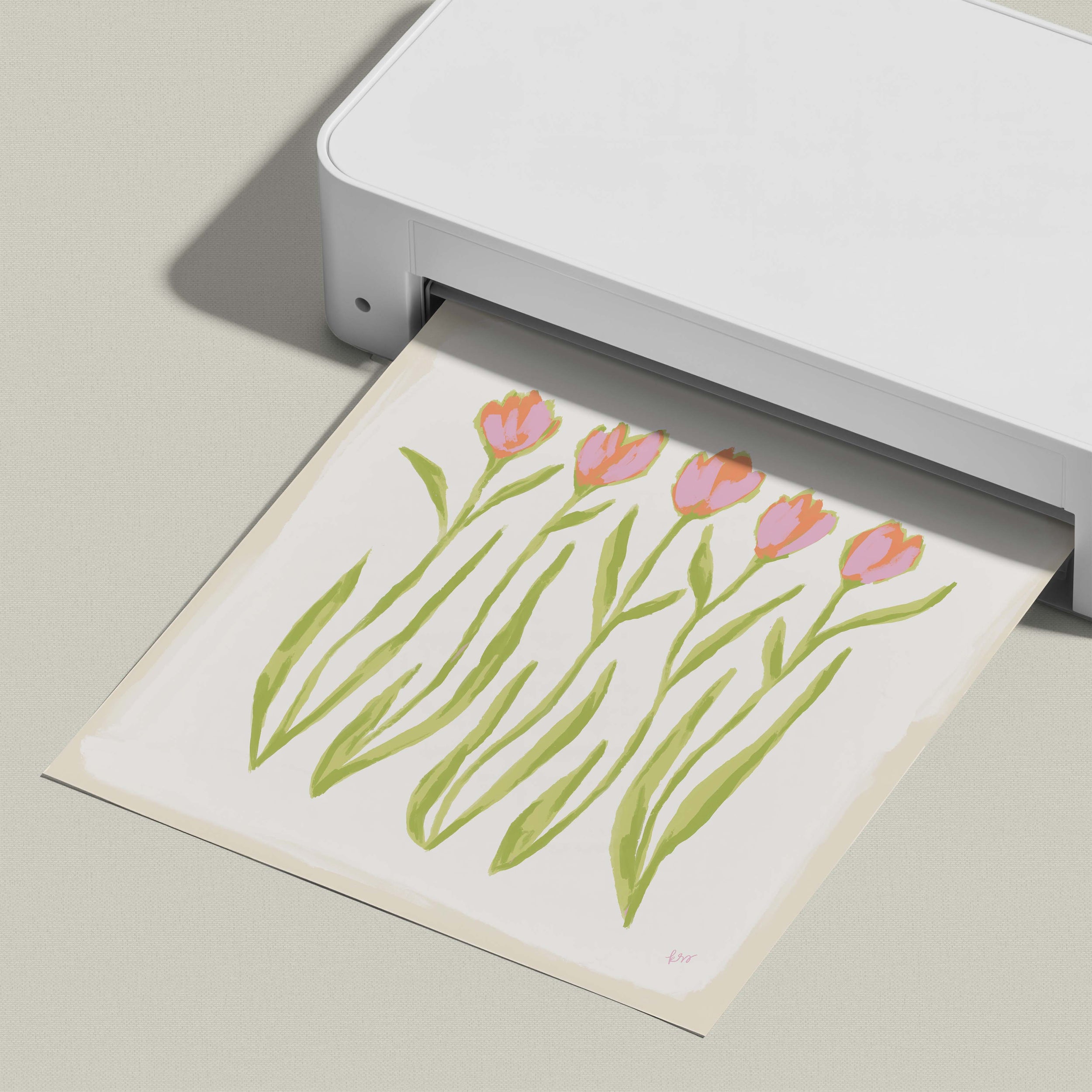 A white printer is printing a paper with a floral design featuring pink and green tulips.