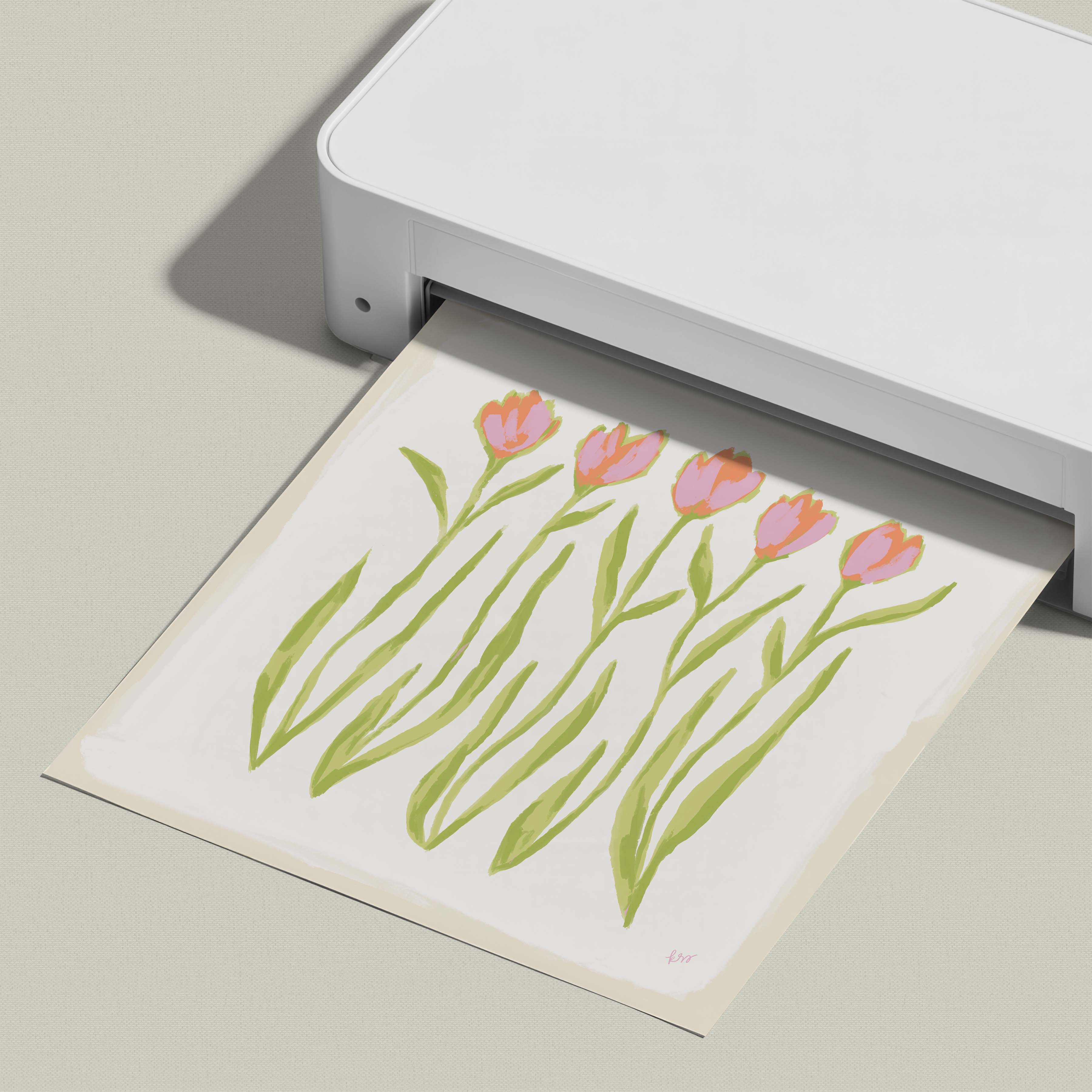 A white printer is printing a paper with a floral design featuring pink and green tulips.