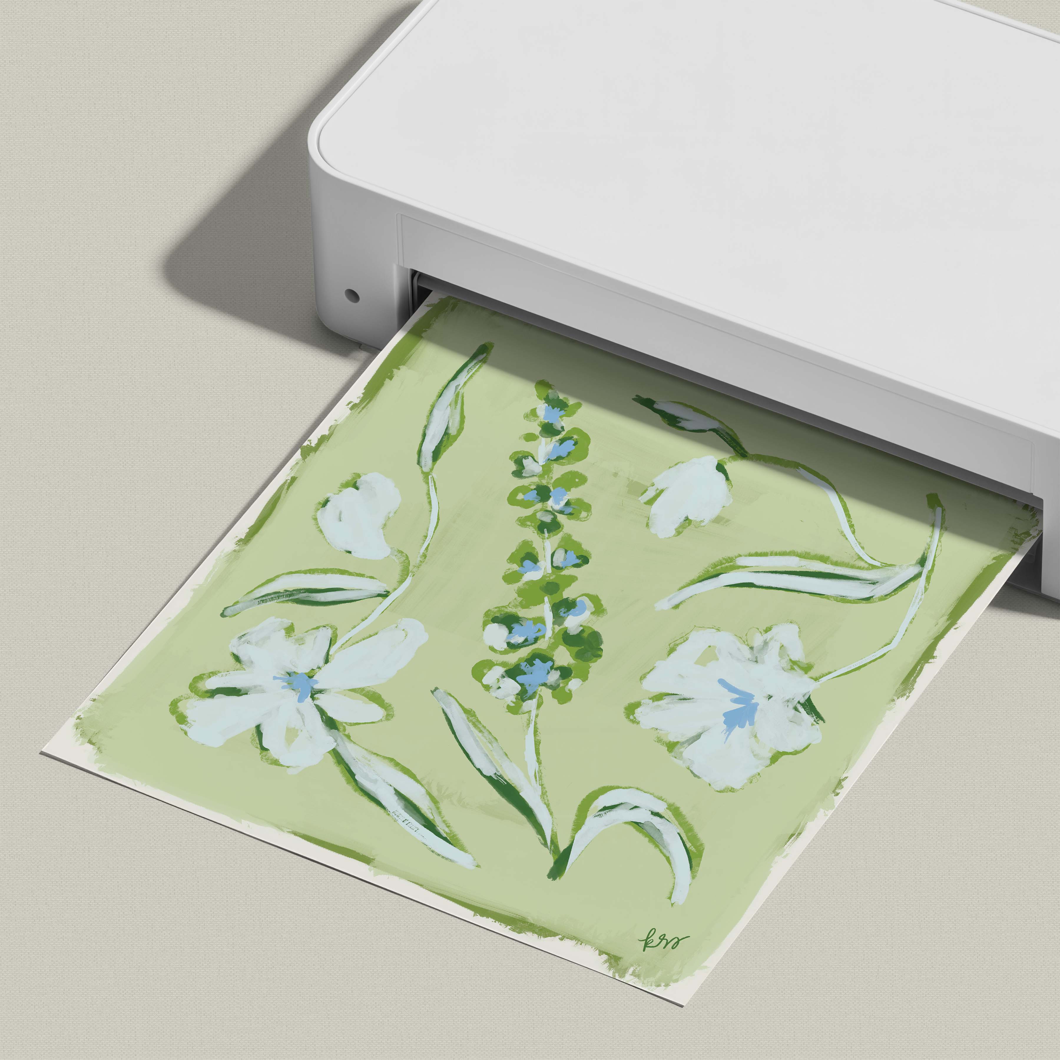 A white printer is displaying a printed image of a floral design on a green background.