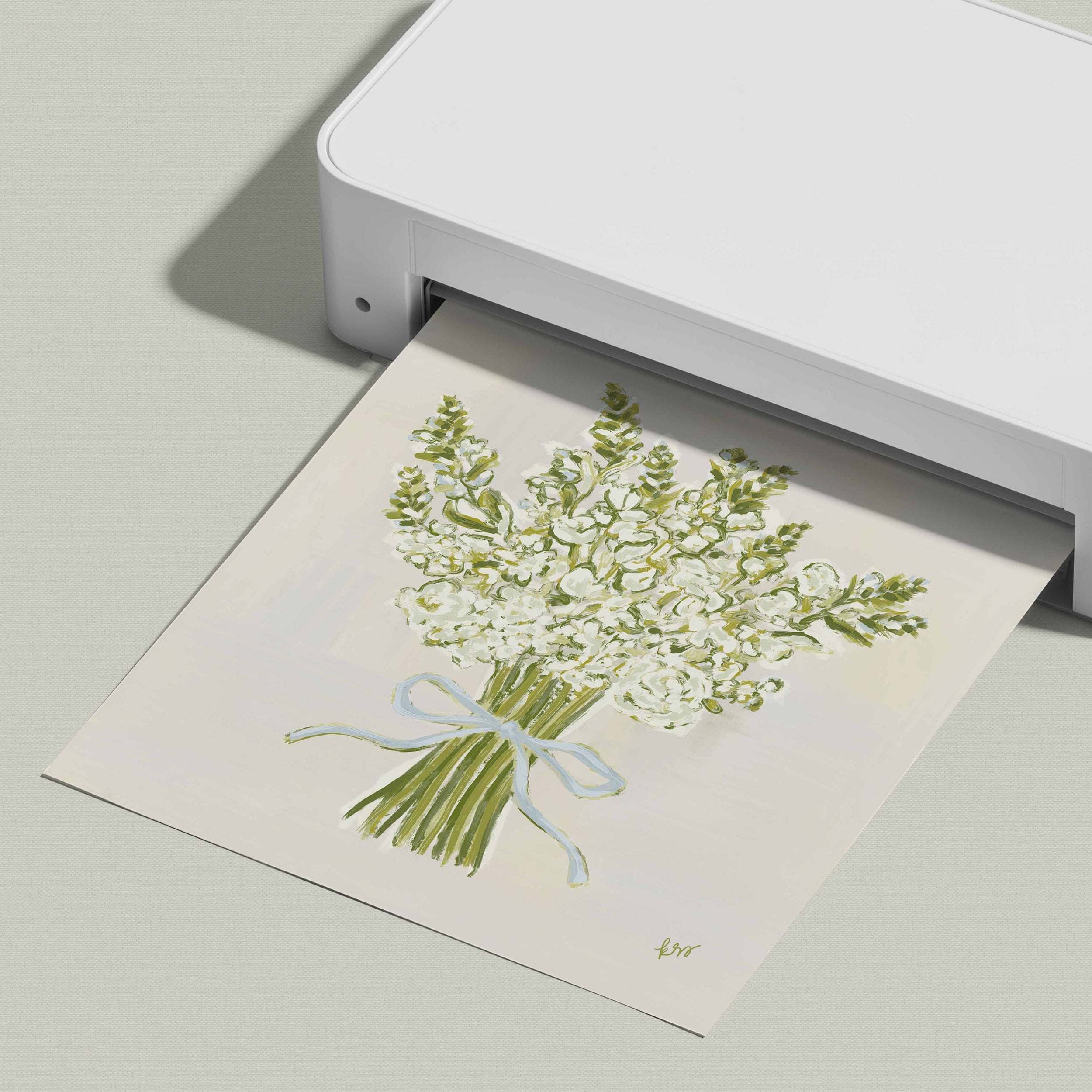 A white printer is printing a picture of a bouquet of white flowers with a blue ribbon.