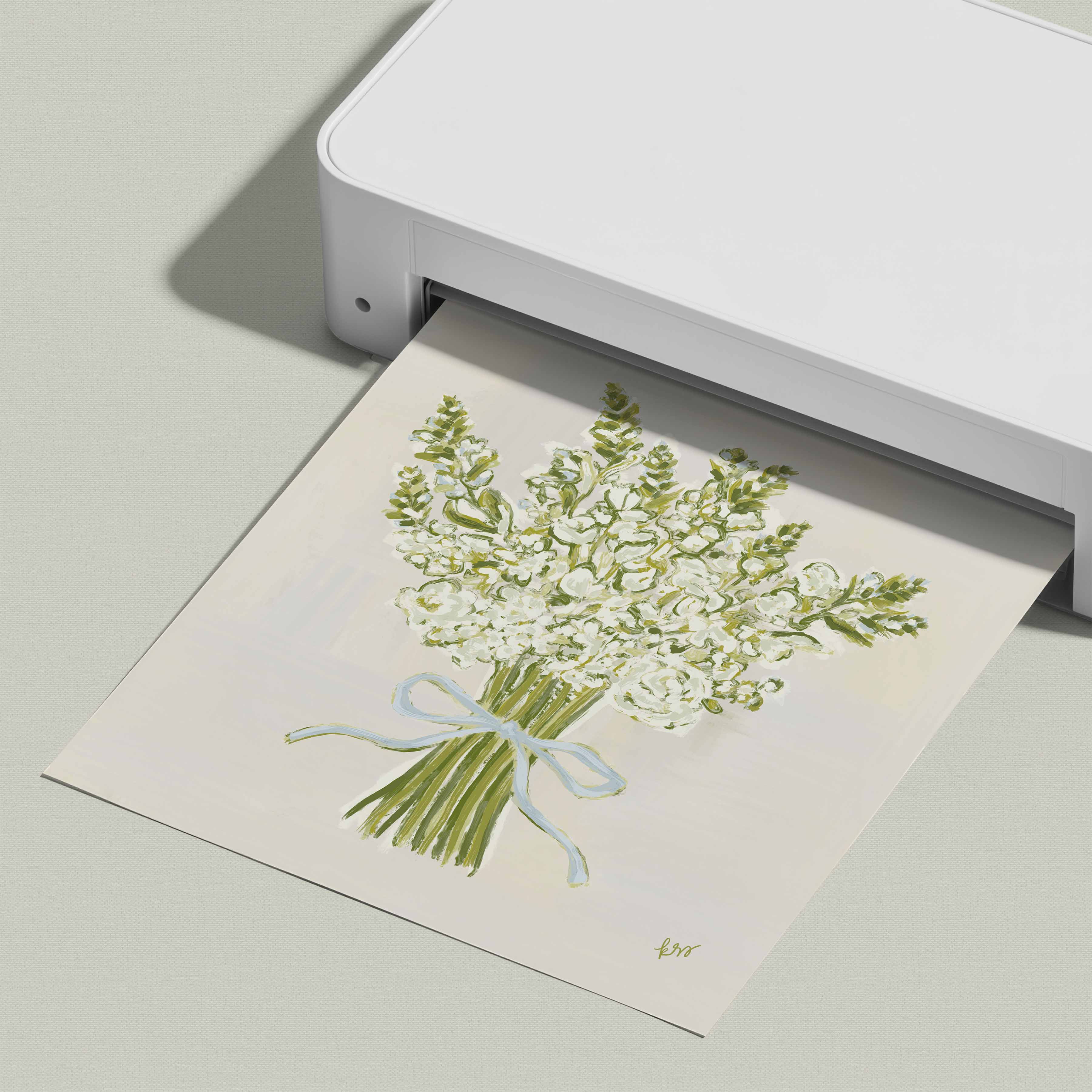 A white printer is printing a picture of a bouquet of white flowers with a blue ribbon.
