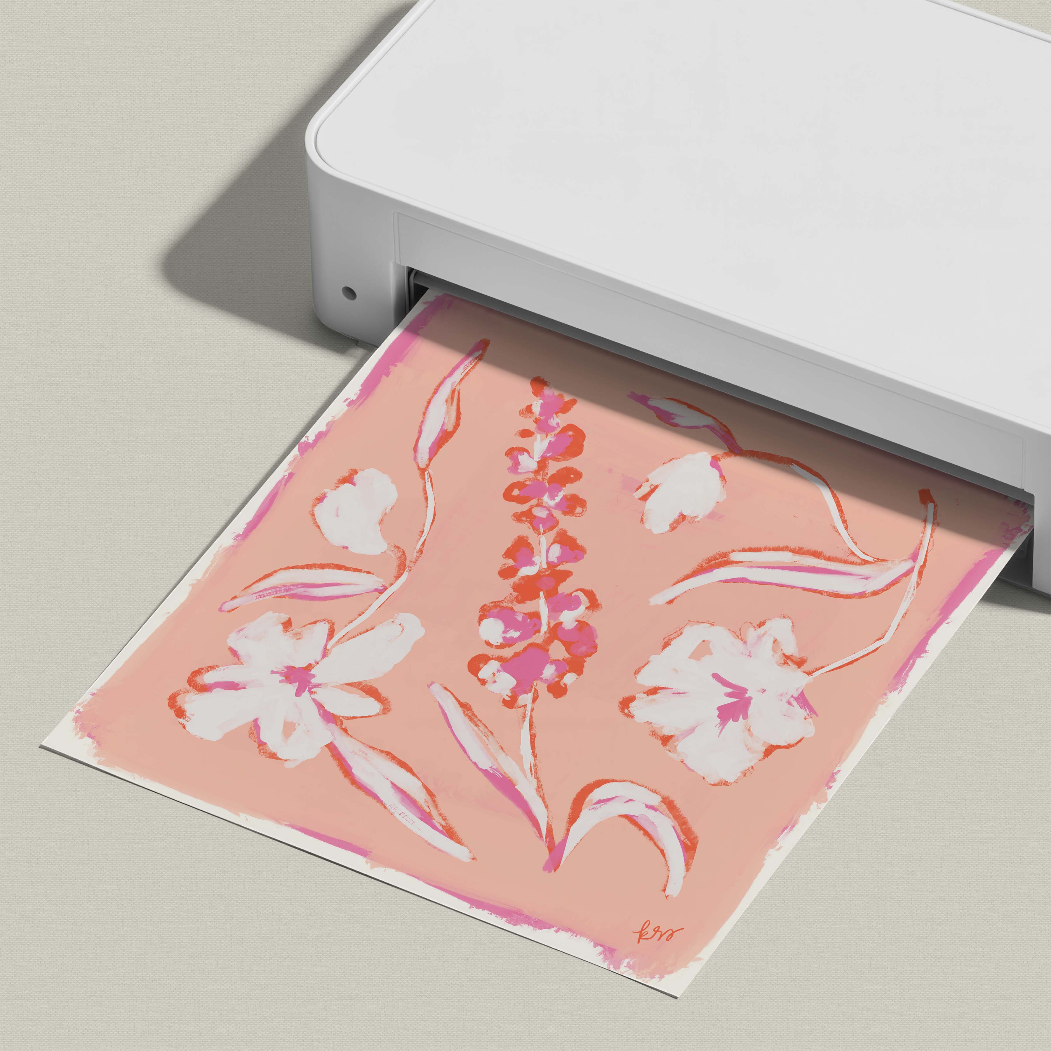 A white printer is displaying a printed image of a pink and white floral design.