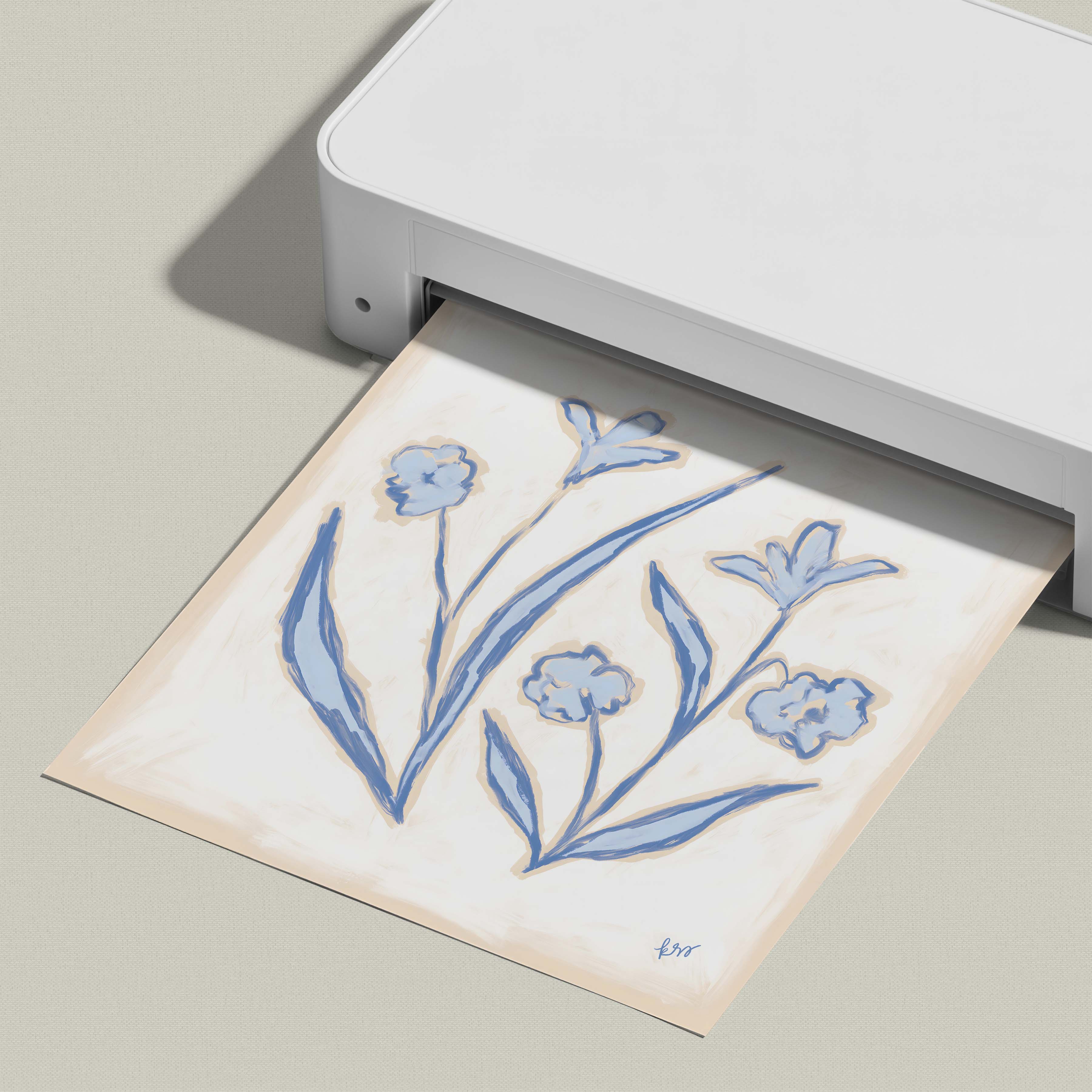 A white printer is printing a paper with a blue floral design on it.