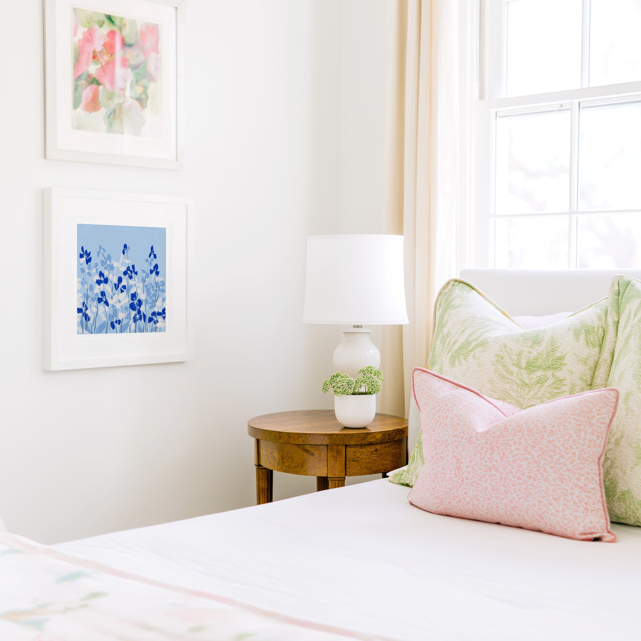 a cozy bedroom corner with a bed, a wooden nightstand, and a framed artwork on the wall.