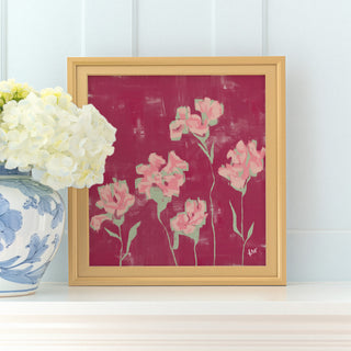 a framed painting of pink flowers on a white shelf, with a vase of white hydrangeas placed next to it.