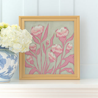 a framed painting of pink flowers on a white shelf, accompanied by a vase of white hydrangeas.