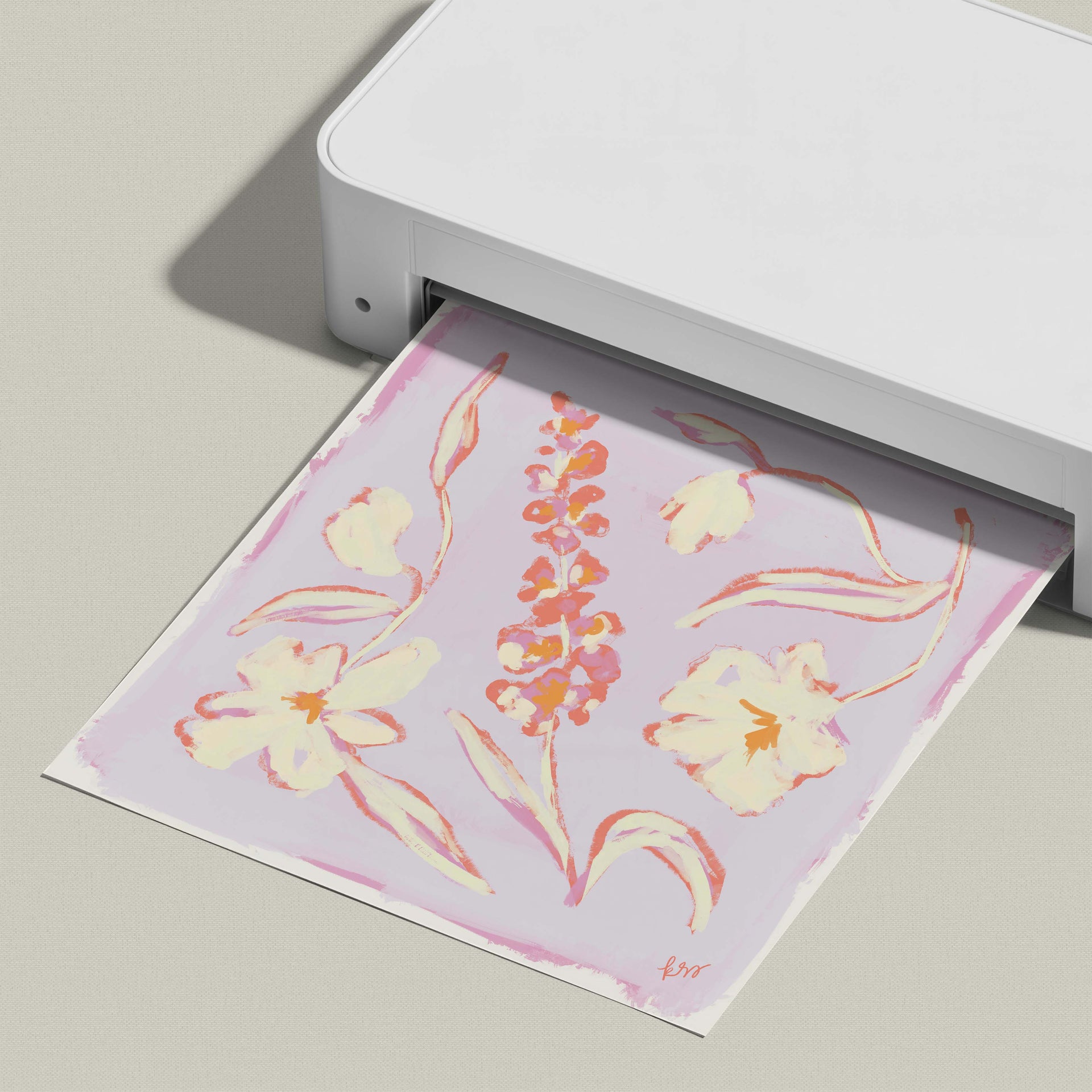 A white printer is displaying a printed image of a floral design on a pink background.