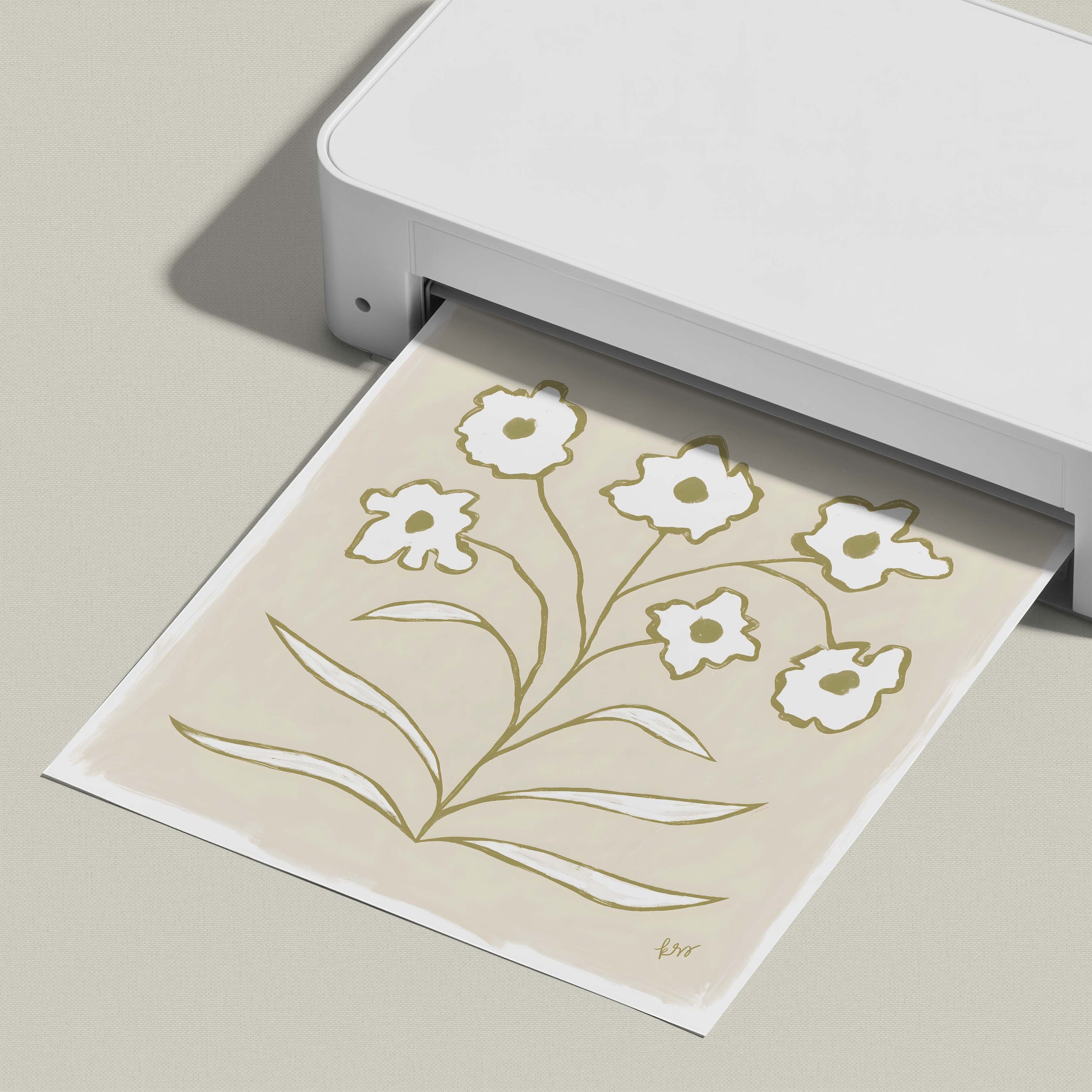 A white printer is printing a paper with a floral design on it.
