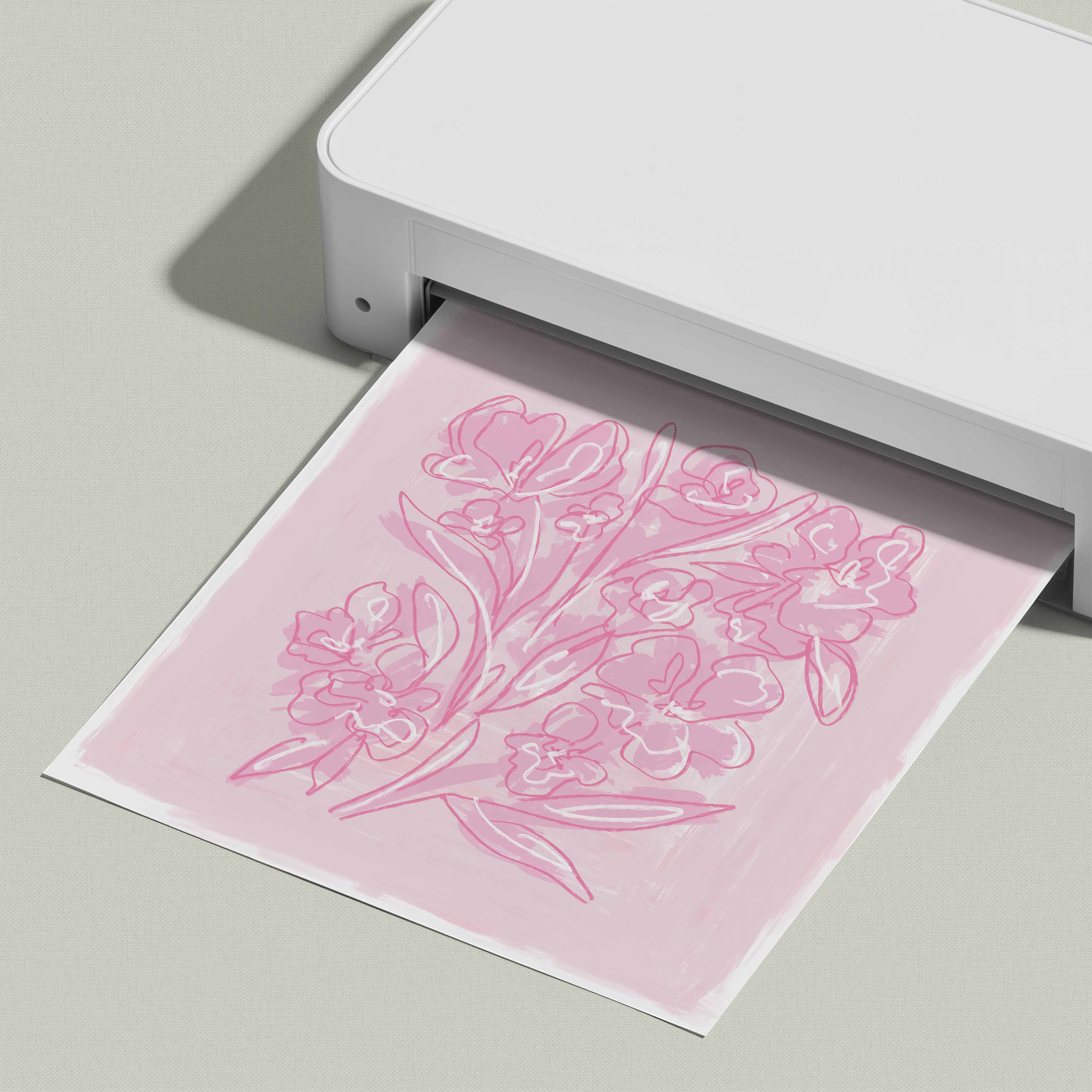 A white printer is printing a pink floral design on a piece of paper.