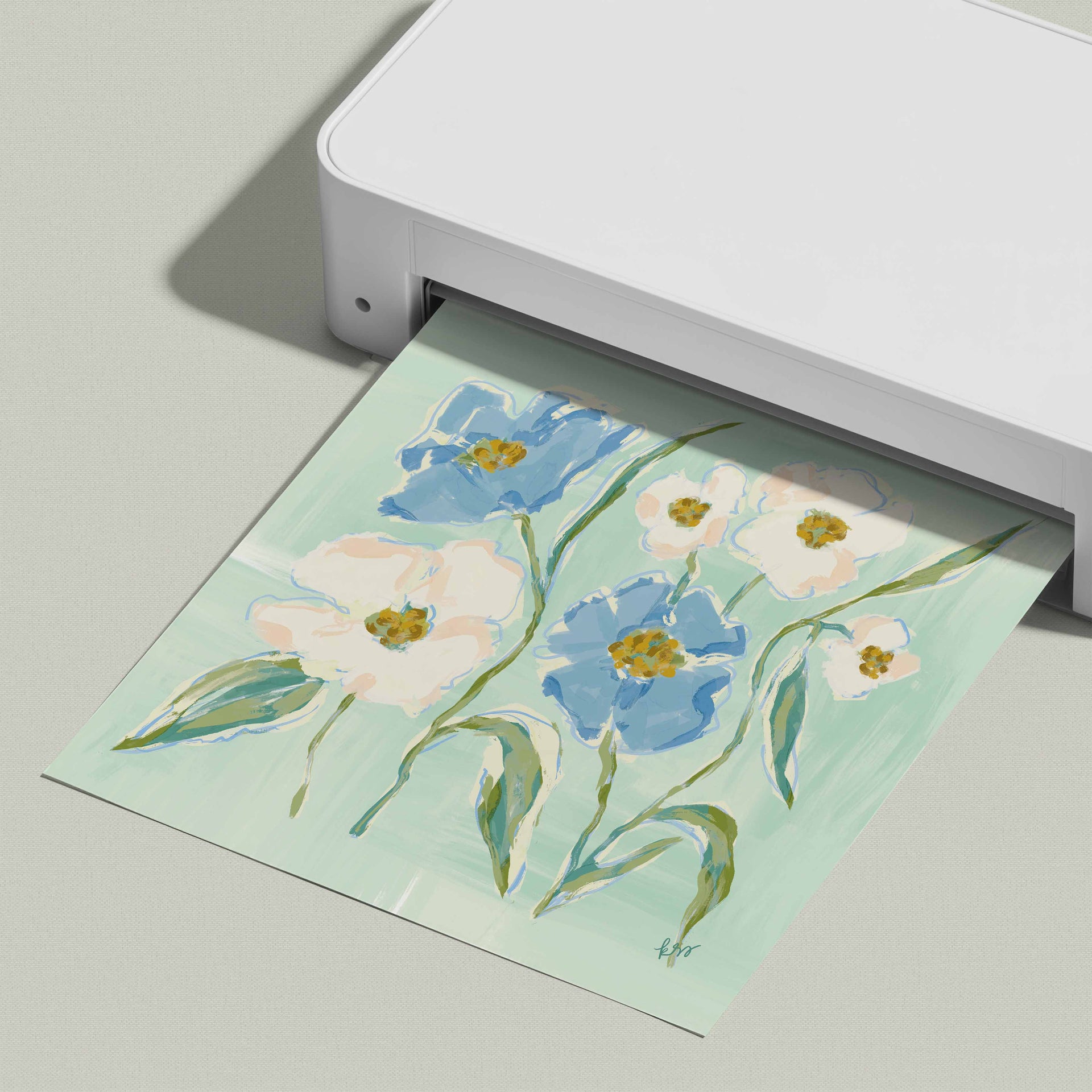 A white printer is printing a colorful floral print on a light green background.