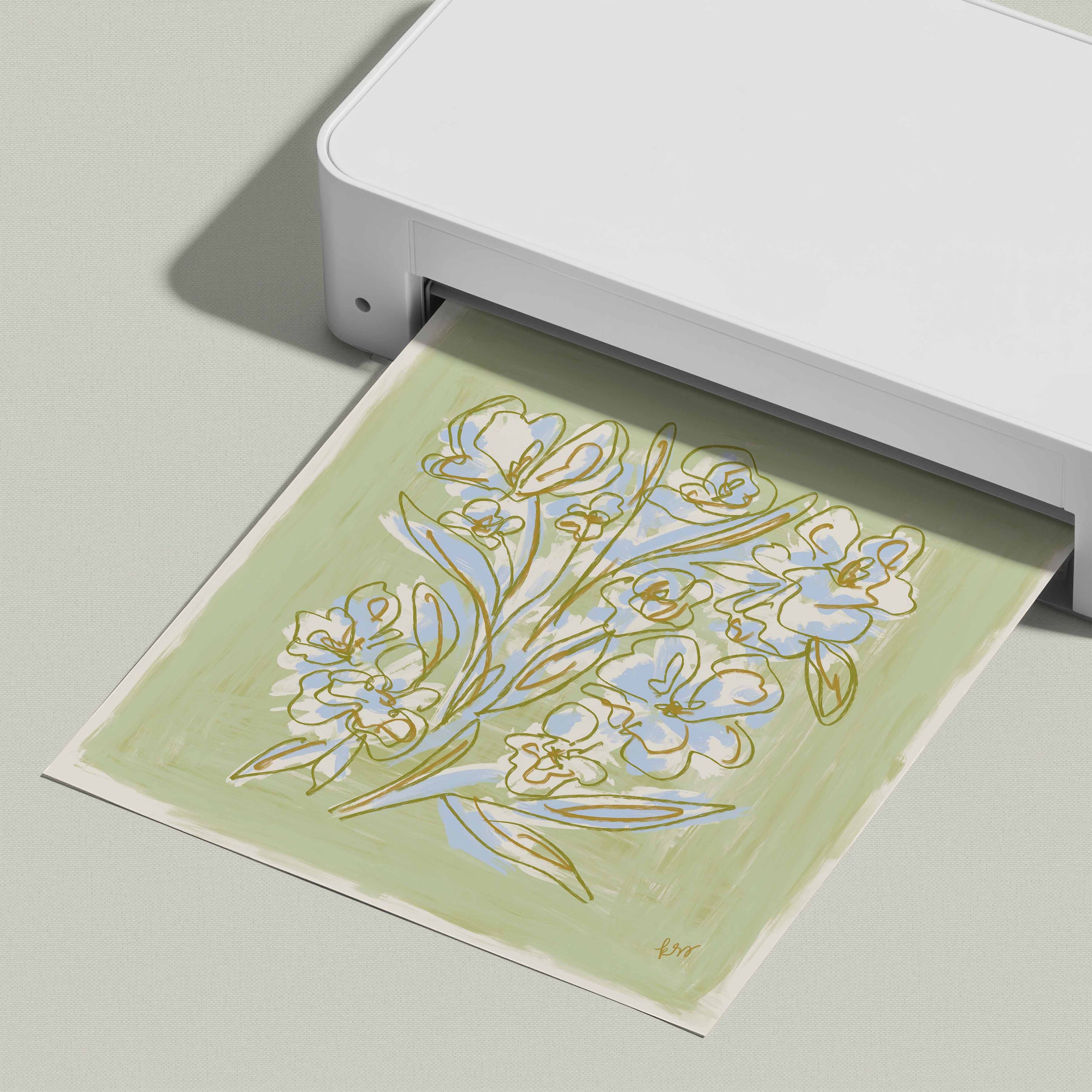 A white printer is printing a green and white floral design on a piece of paper.
