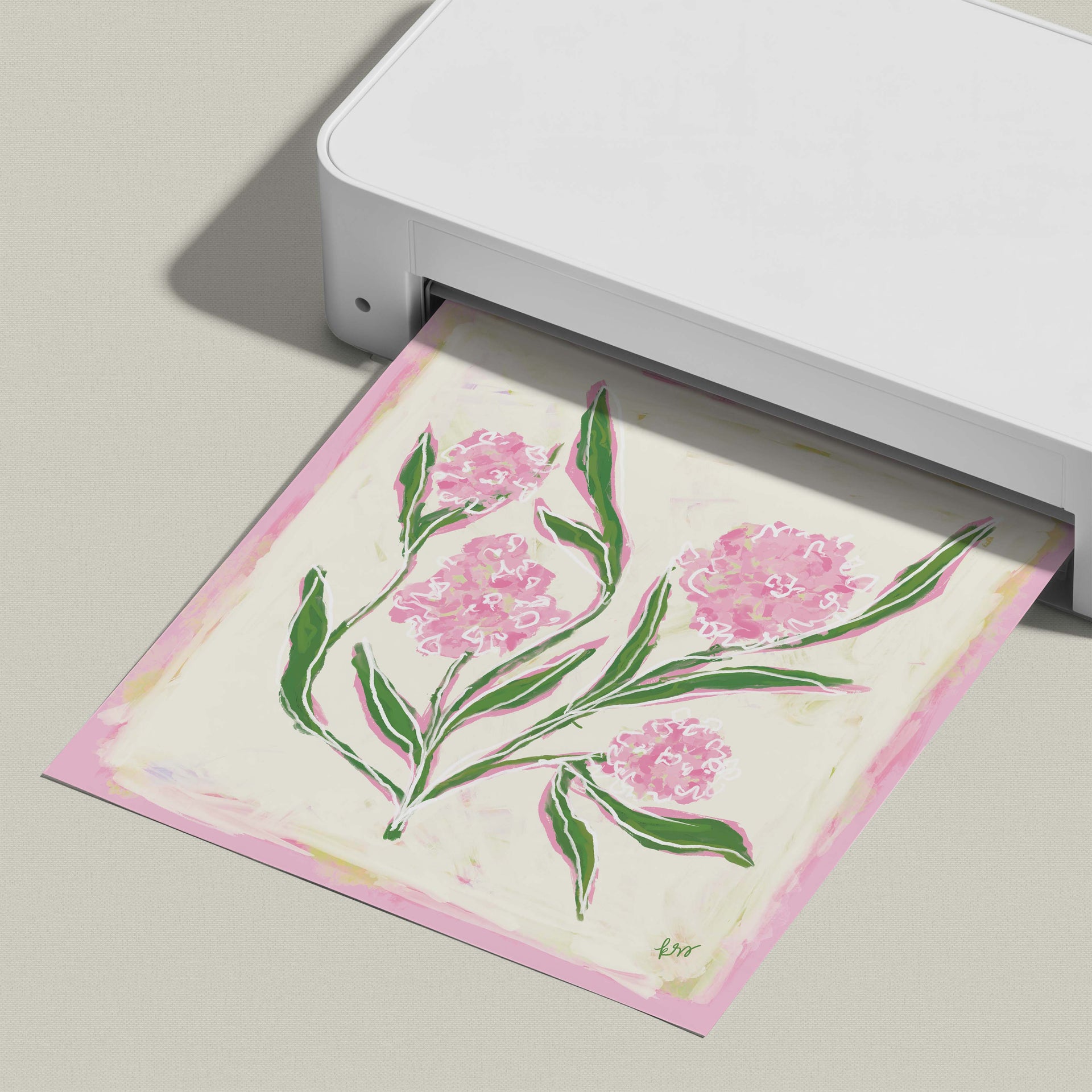 A white printer is displaying a printed image of a pink flower with green leaves.