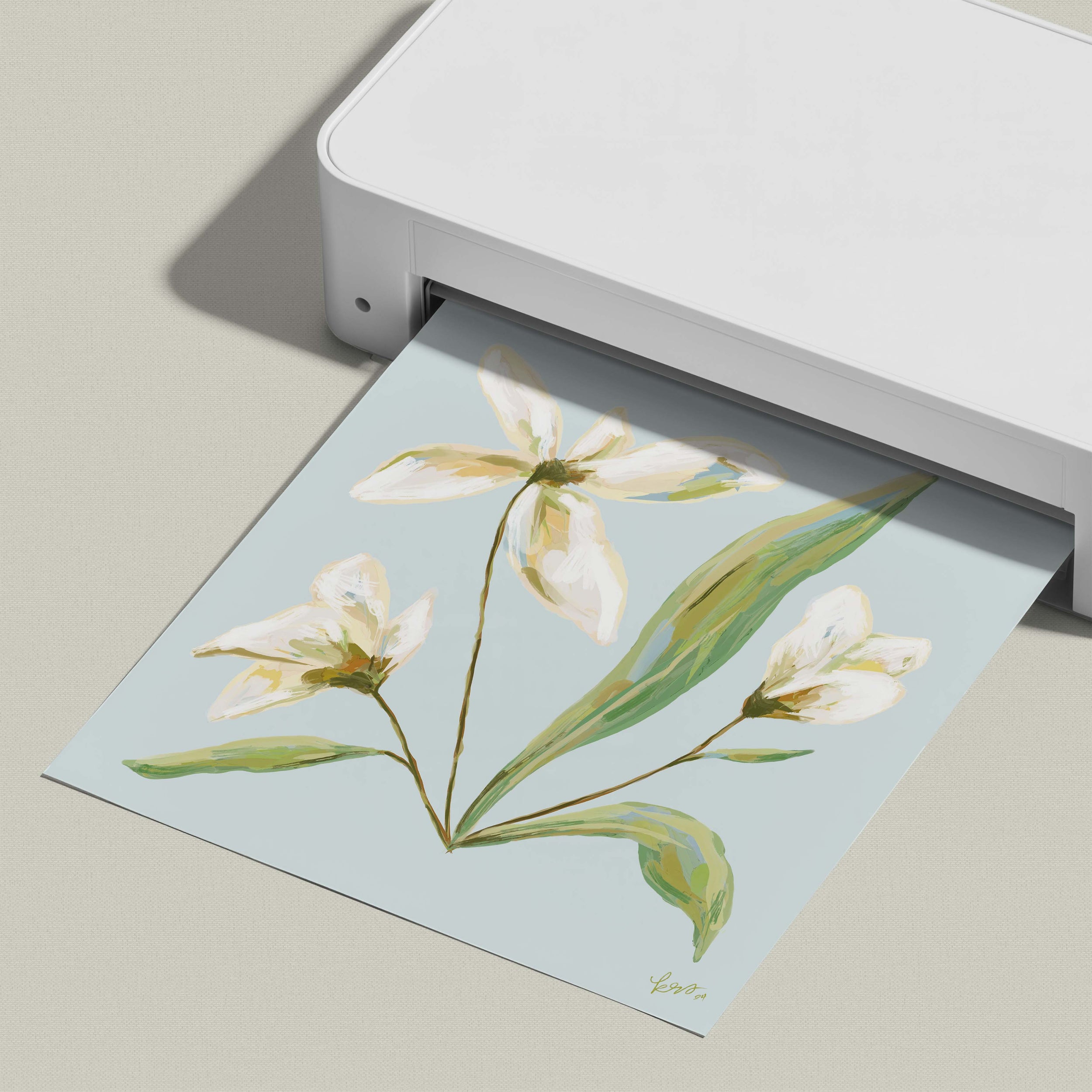 A white printer is printing a paper with a floral design featuring white flowers and green leaves.